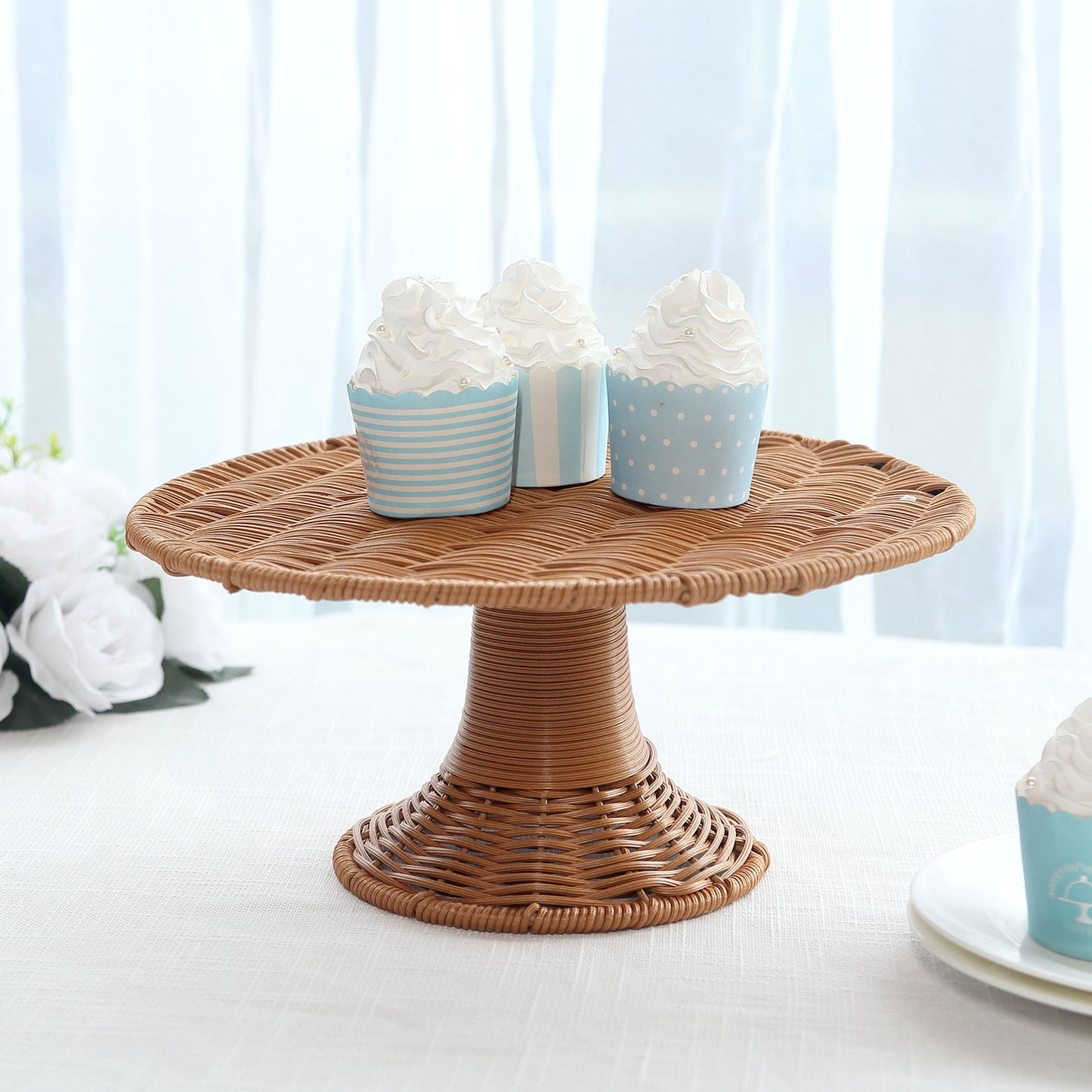 Natural brown wicker pedestal cupcake stand with decorative cupcakes.
