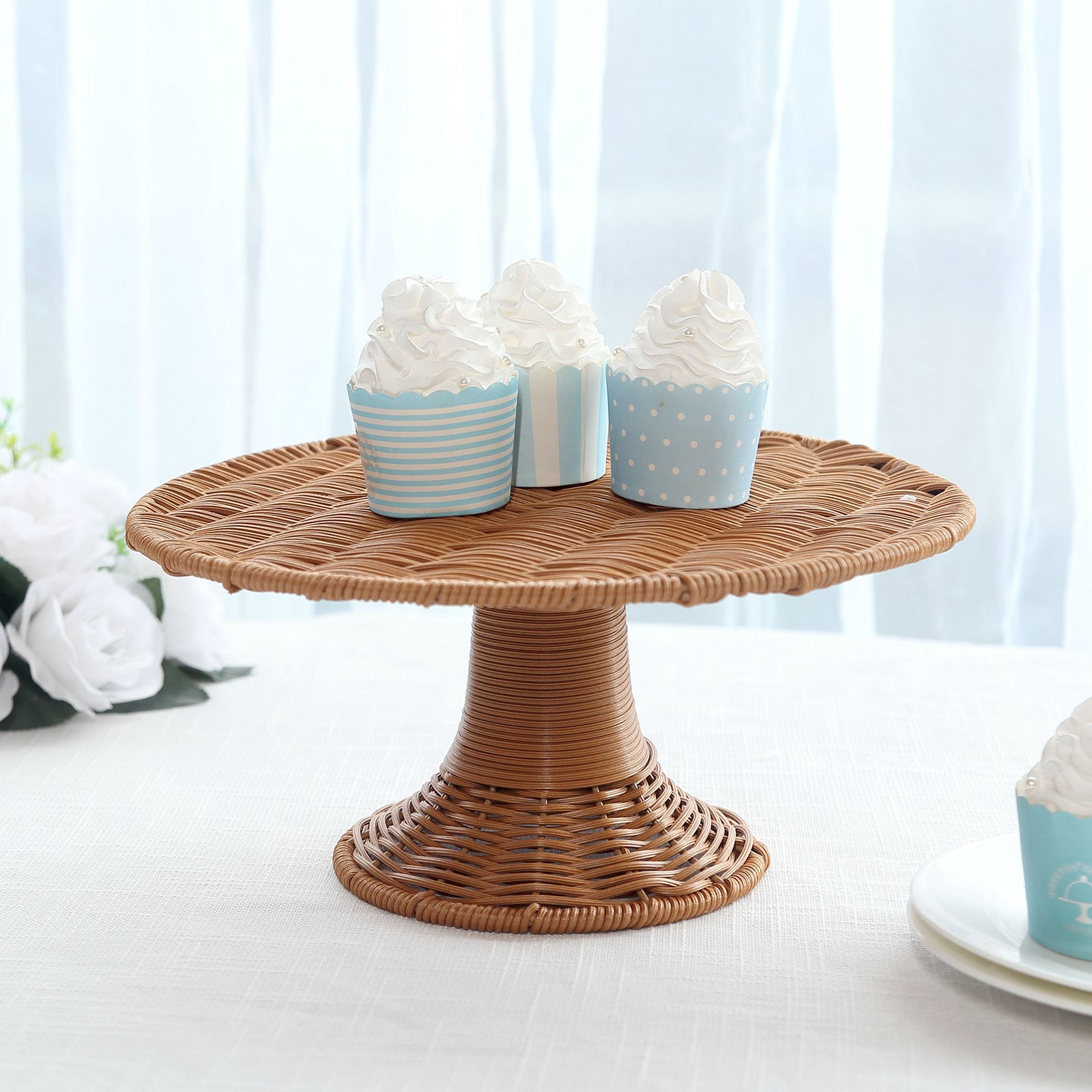 Natural brown wicker pedestal cupcake stand with decorative cupcakes.