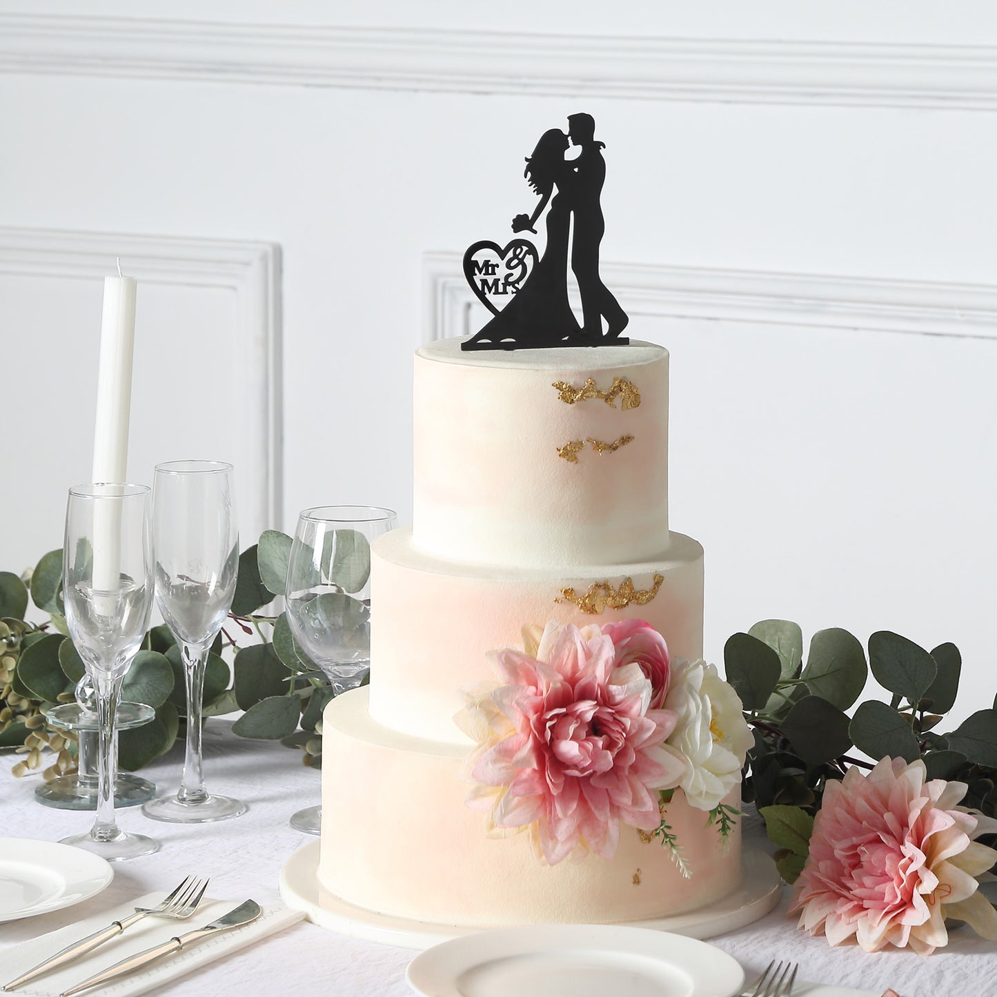 Black acrylic Mr and Mrs wedding cake topper on a decorated cake.