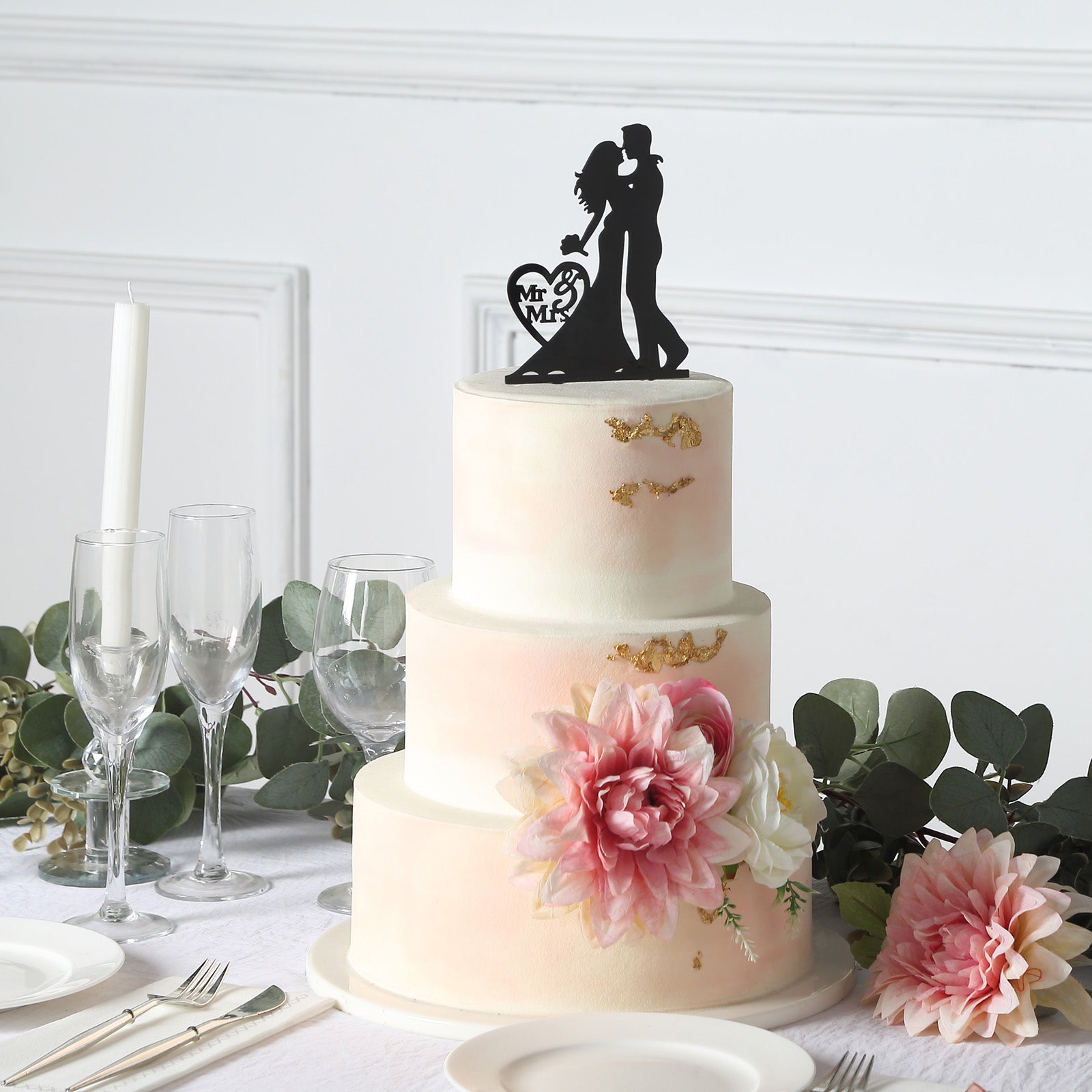 Black acrylic Mr and Mrs wedding cake topper on a decorated cake.