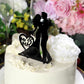 Black wedding cake topper featuring a silhouette of a bride and groom.