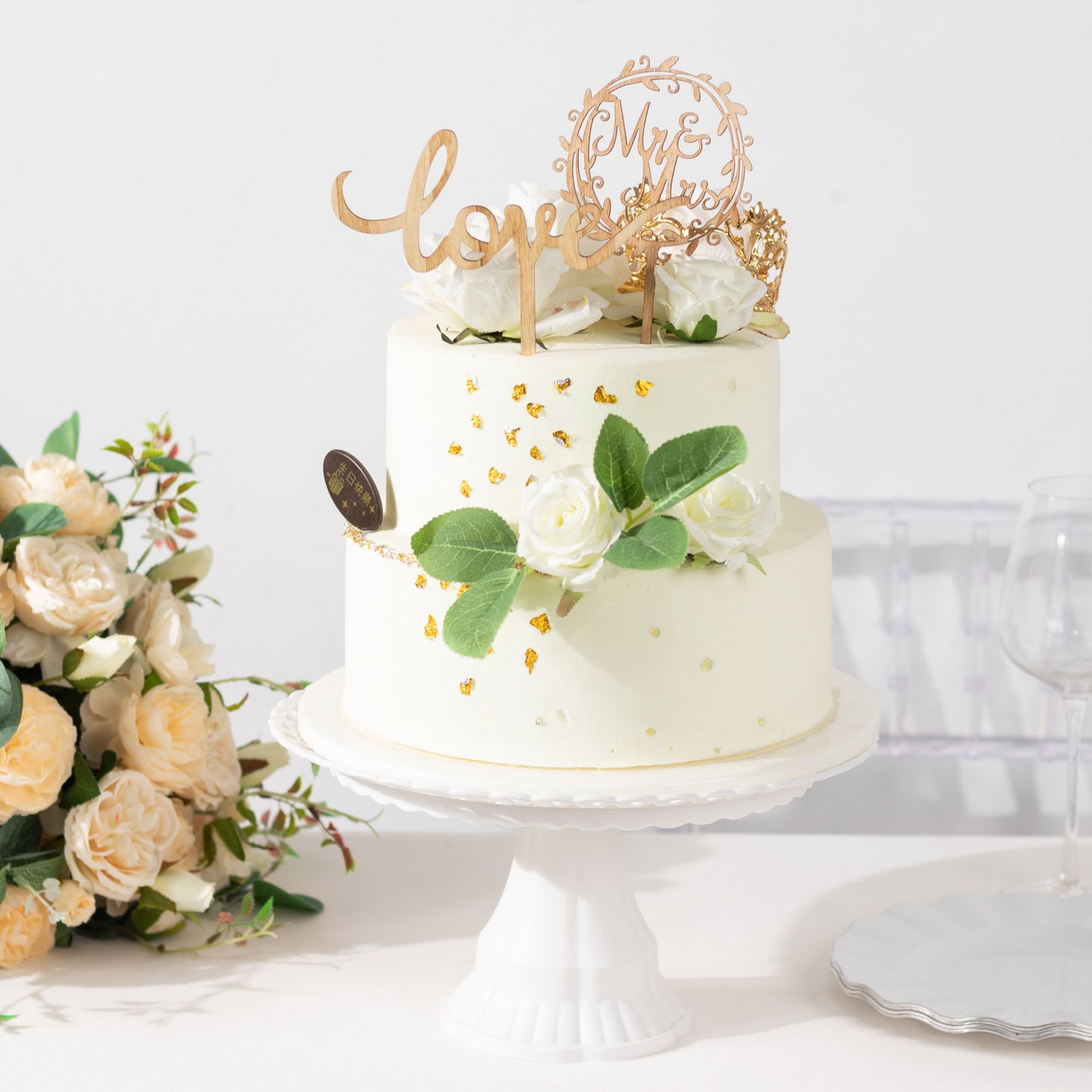 Rustic wooden Mr & Mrs and Love cake topper on a white wedding cake.