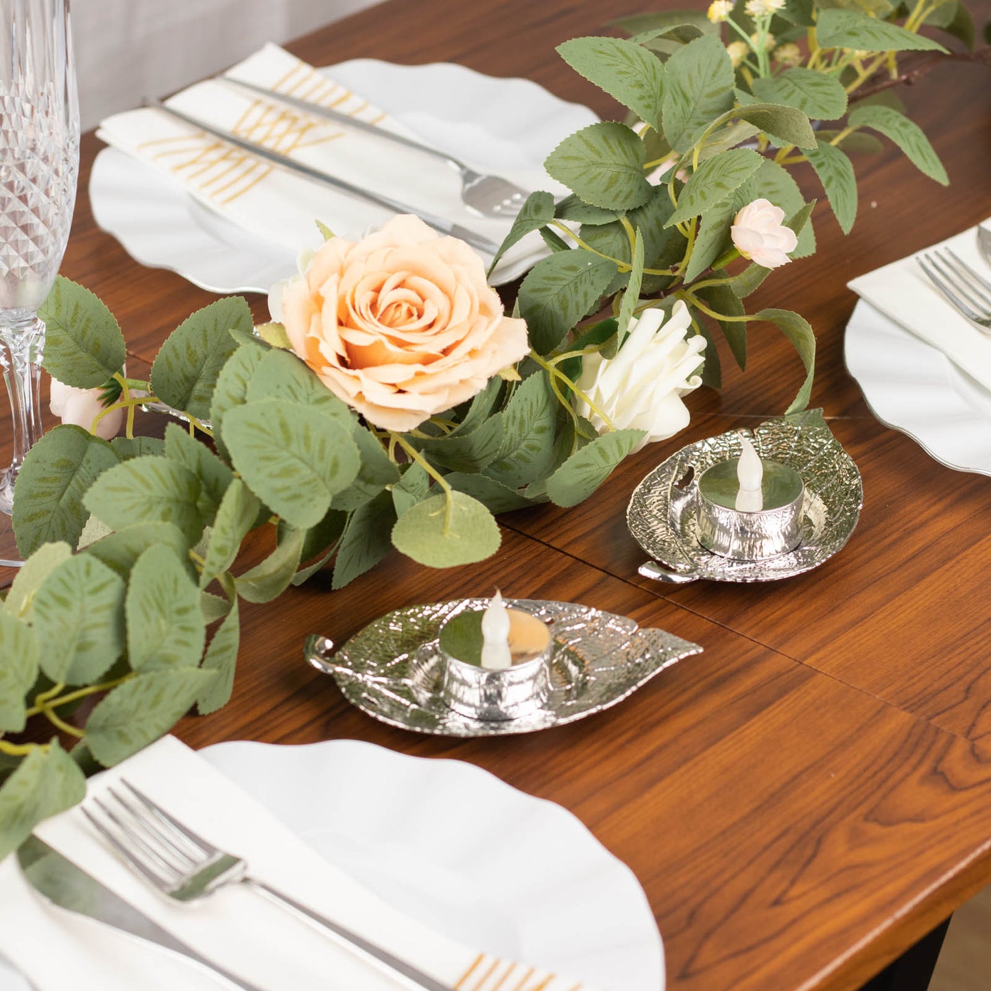 5" shiny silver metal maple leaf tealight candle holders on a table setting.