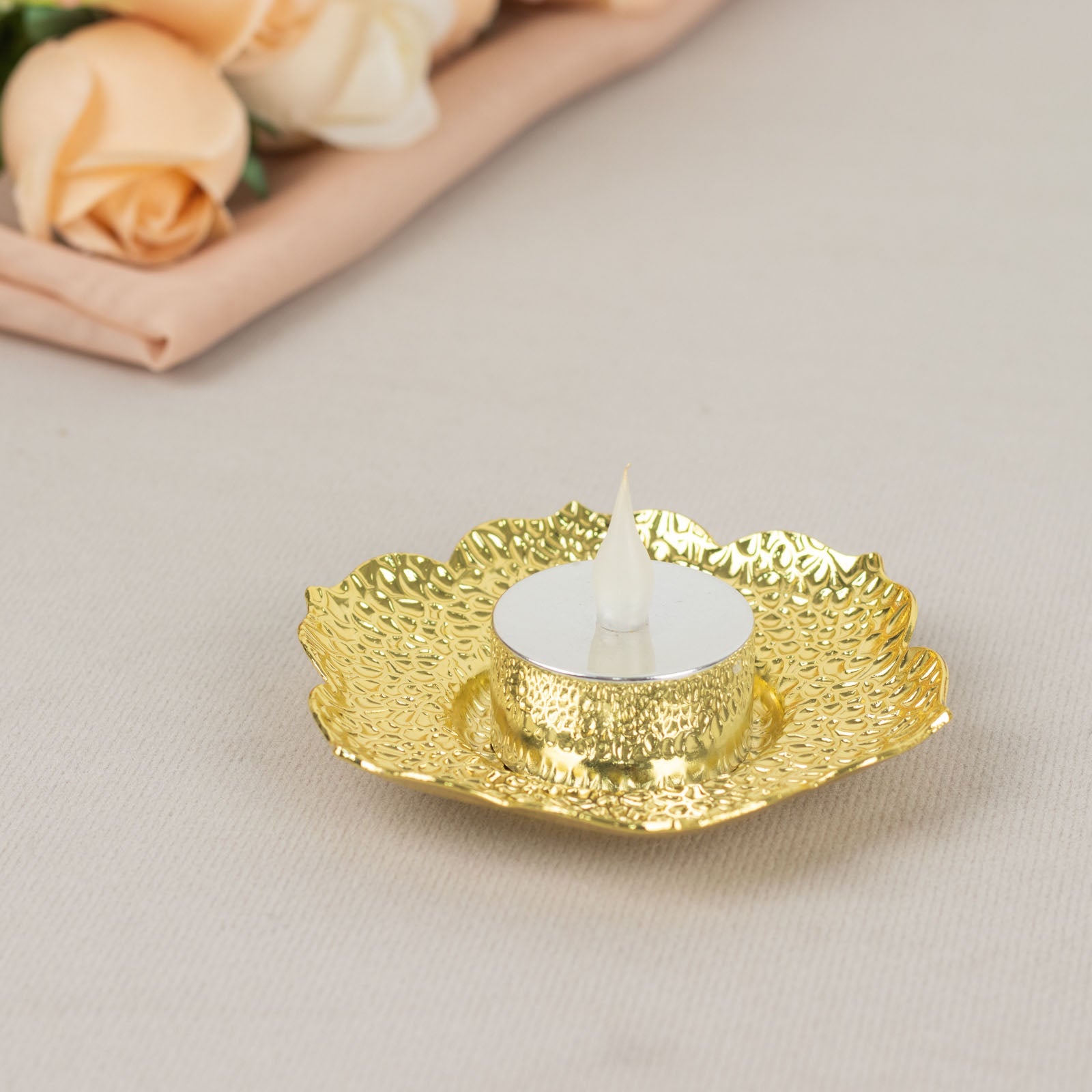 Shiny gold plum blossom tealight candle holder on a vintage mini saucer.