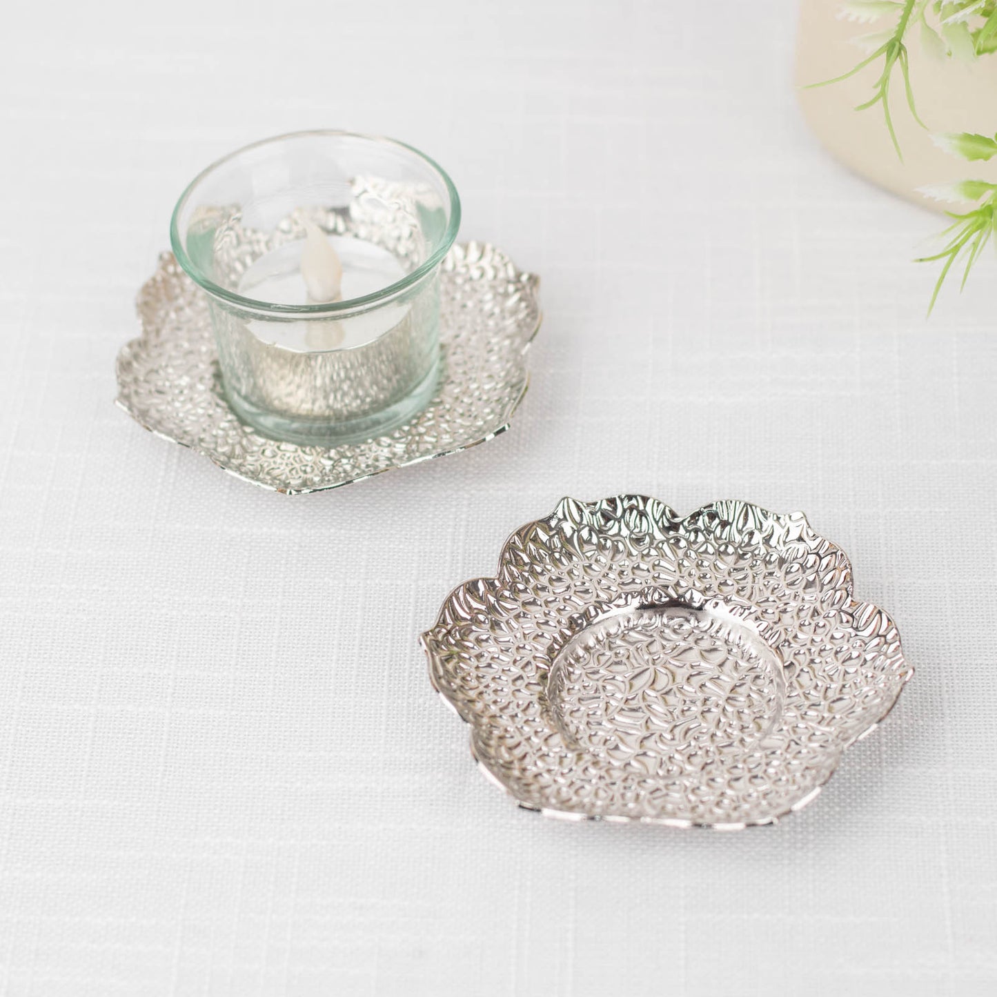 Shiny silver metal plum blossom tealight candle holders and saucers.