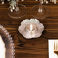 Shiny silver metal plum blossom tealight candle holder on a wooden table.