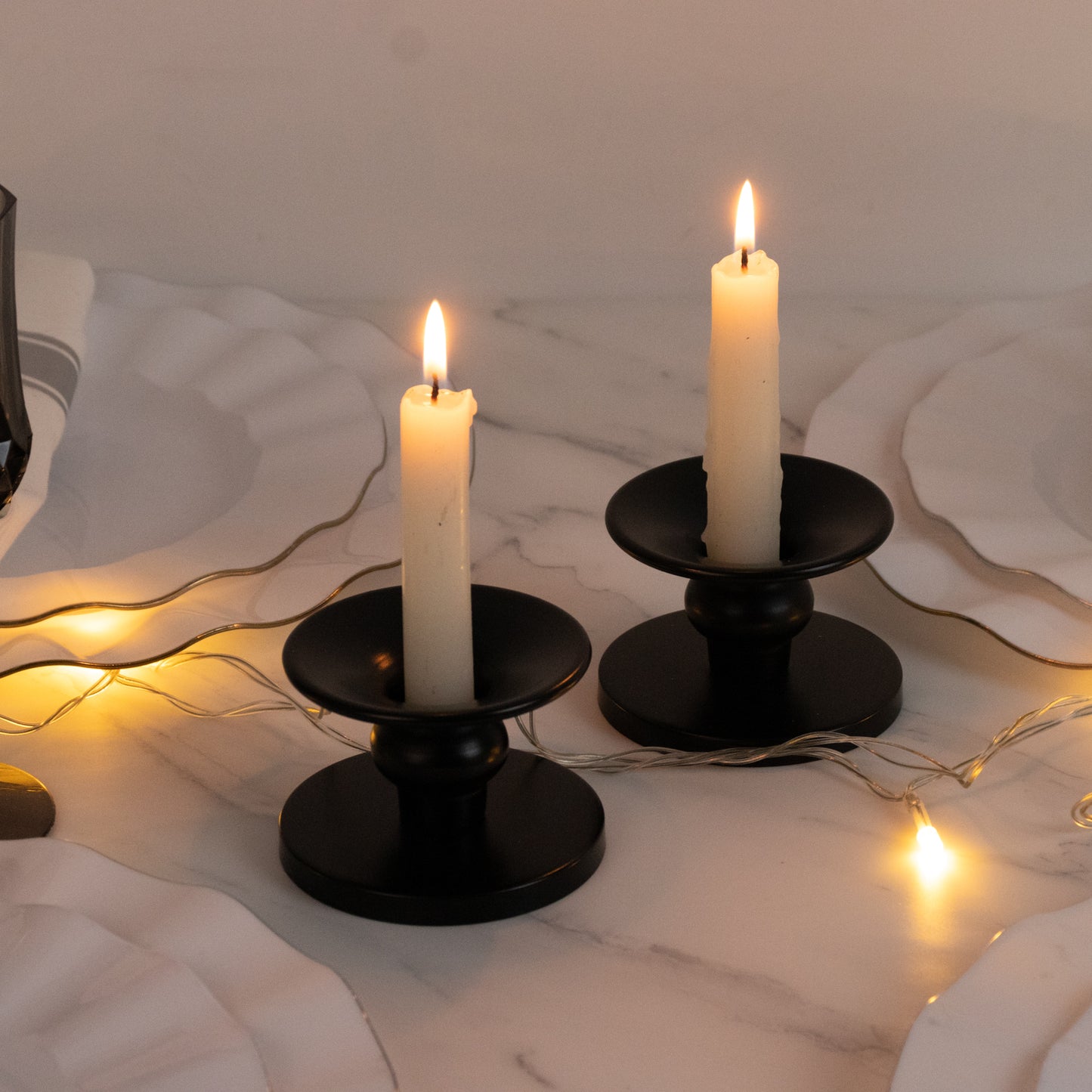 Black metal candle holders with tapered candles, perfect for elegant decor.