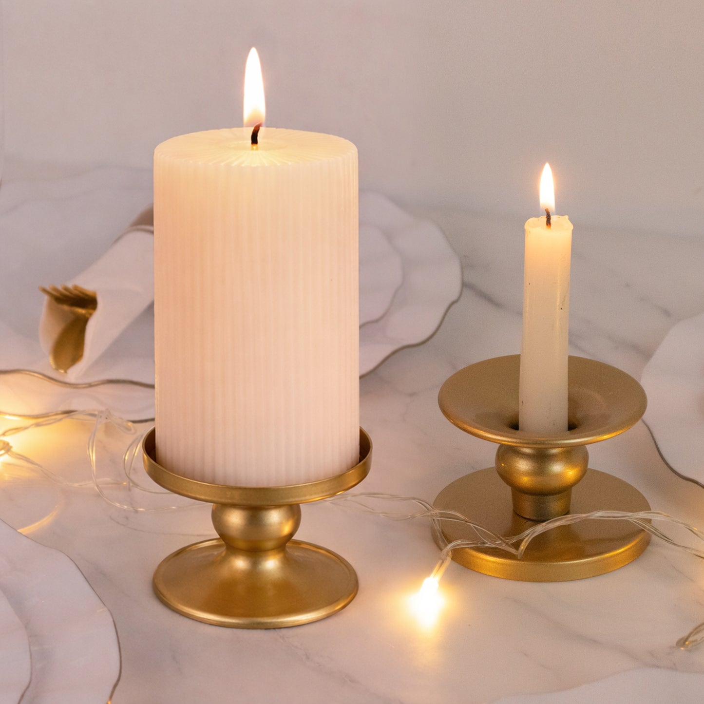 Gold metal candle holders with pillar and taper candles.