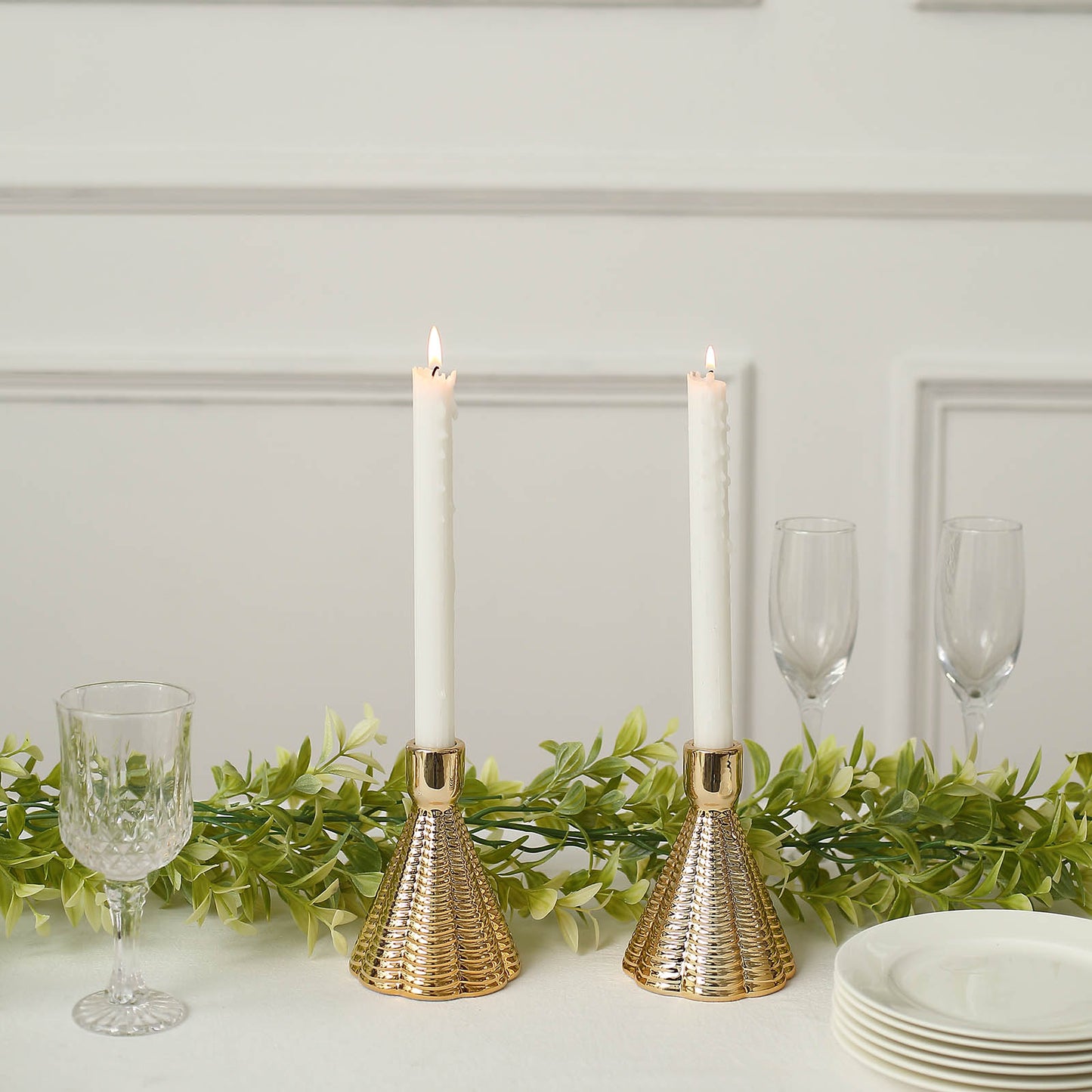Metallic gold ribbed ceramic taper candle holders in a cone shape.