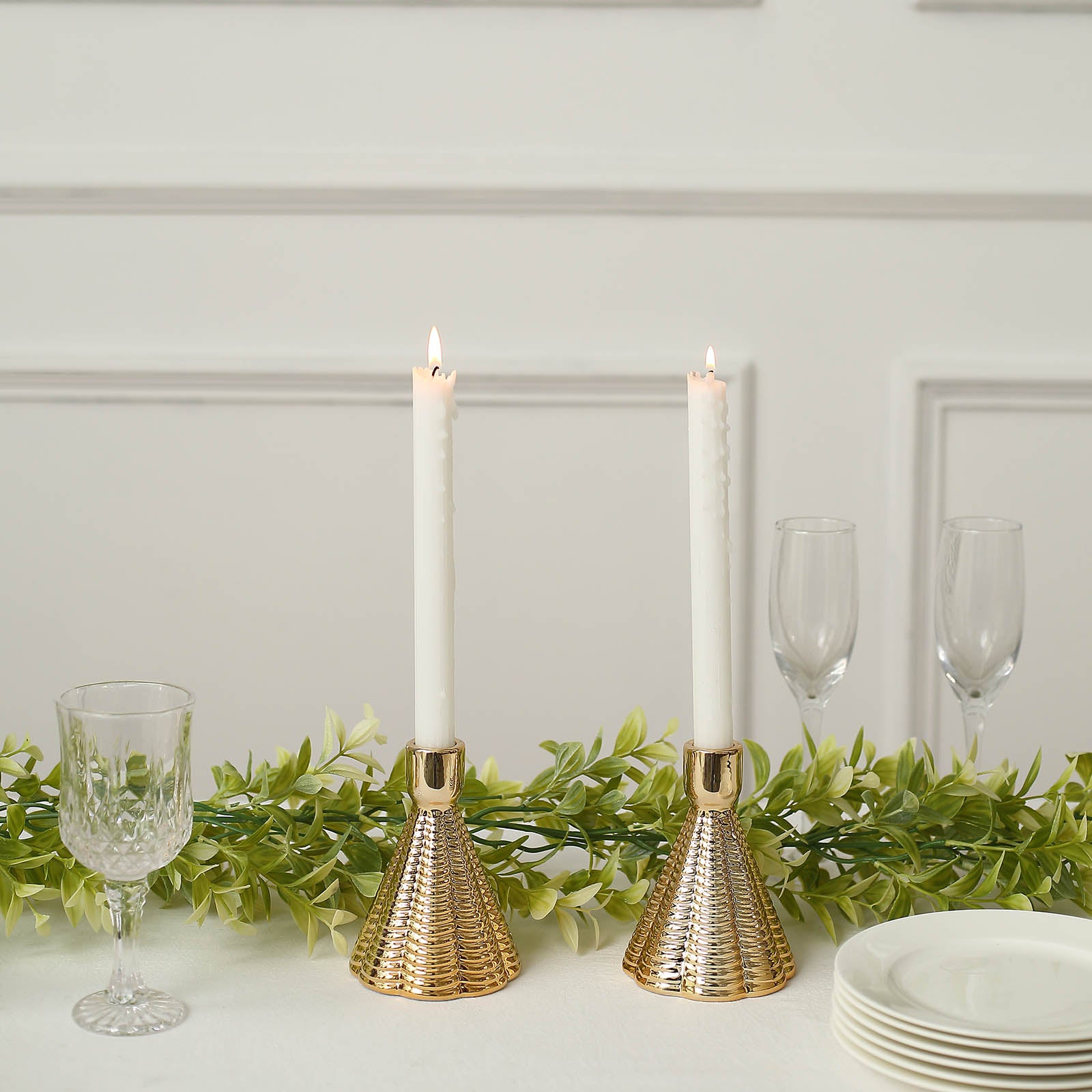 Metallic gold ribbed ceramic taper candle holders in a cone shape.