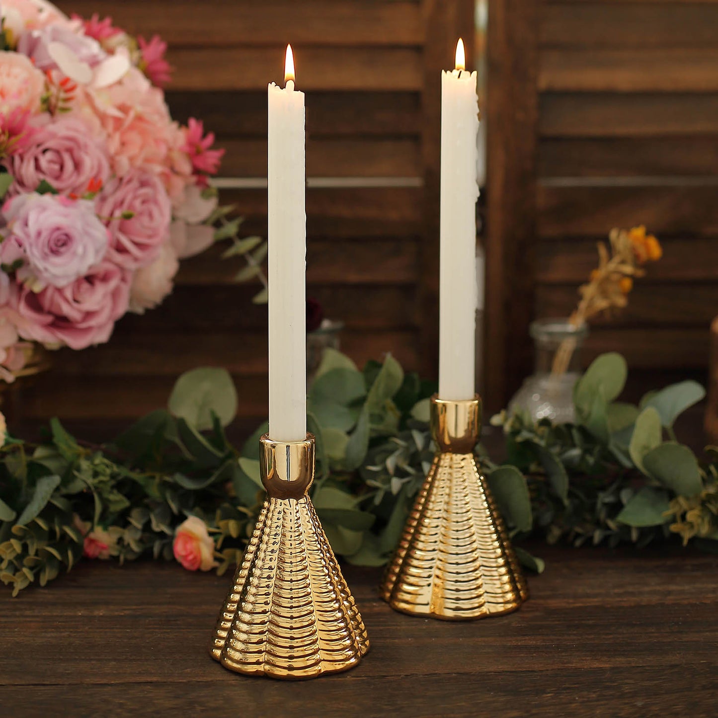 Metallic gold ribbed ceramic taper candle holders with white candles.