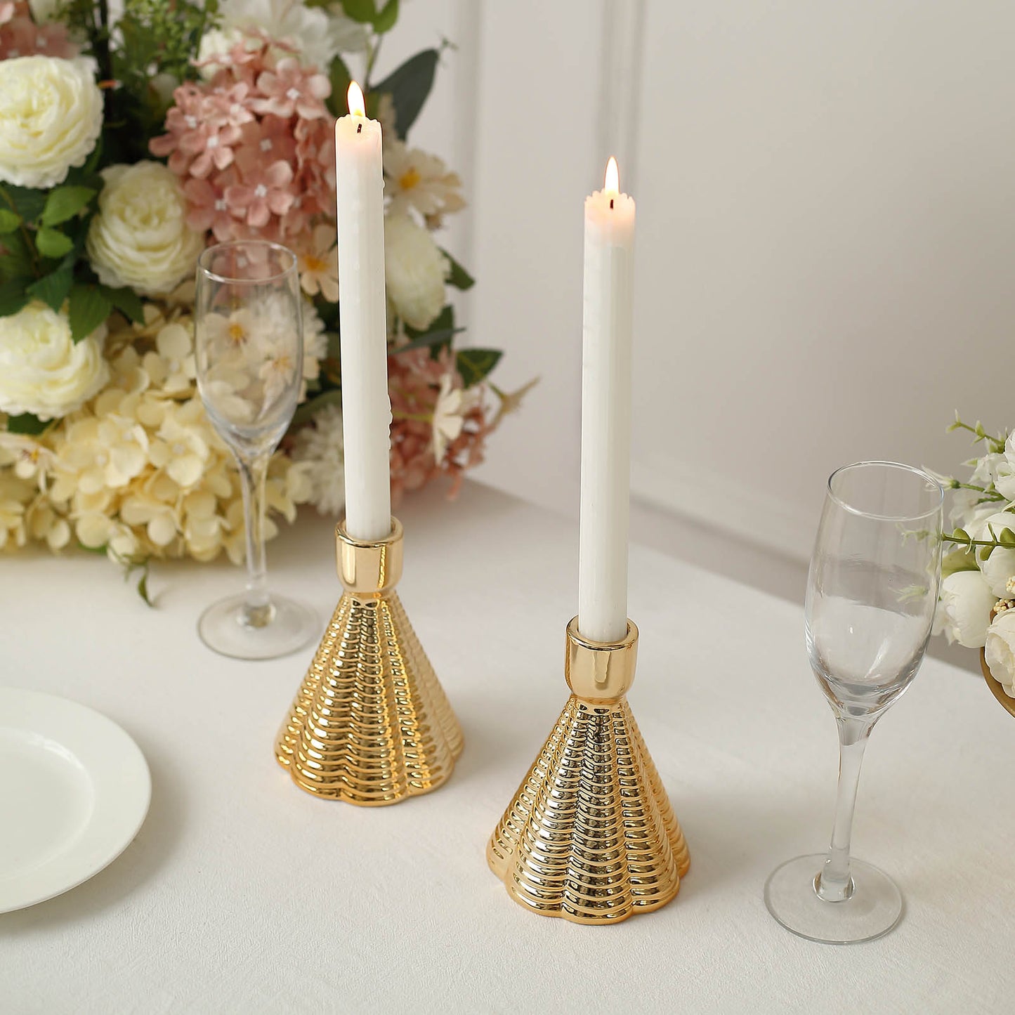Metallic gold ribbed ceramic taper candle holders with white candles.
