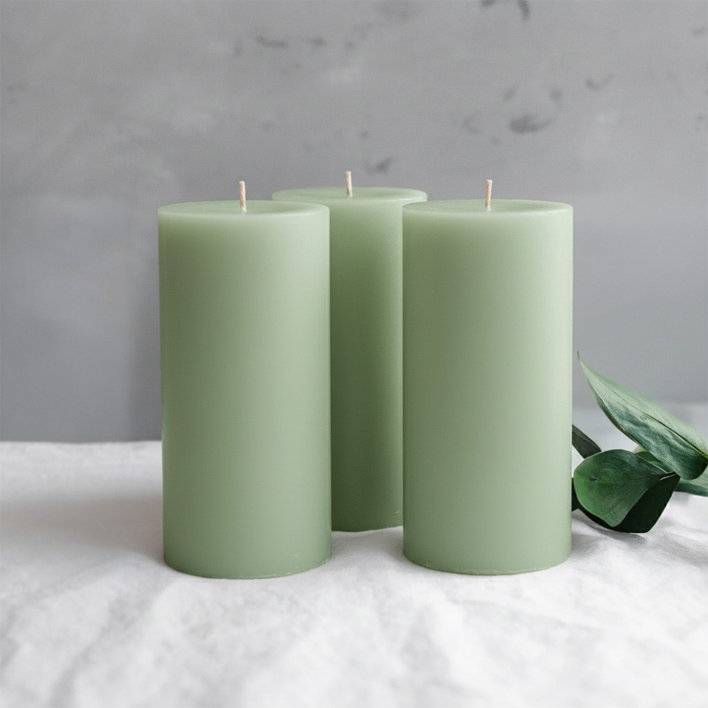 Sage green dripless pillar candles in a set of six.