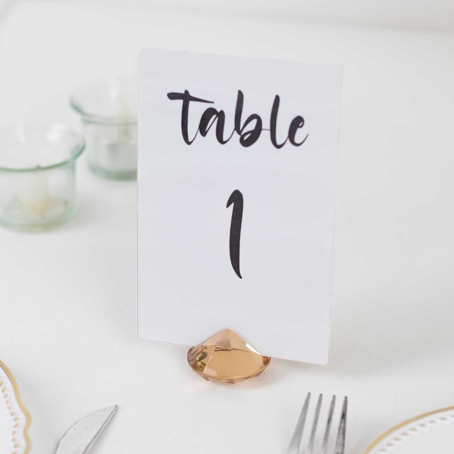 Amber diamond-shaped place card holder with table number decoration.