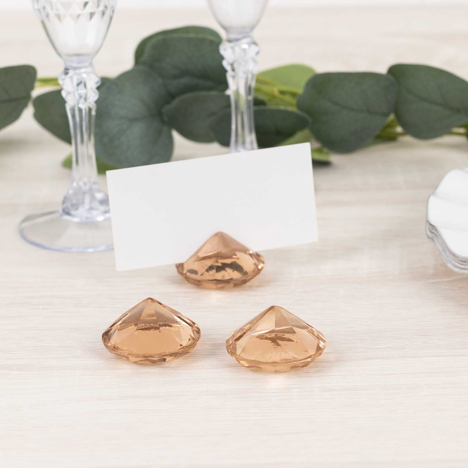 Amber diamond-shaped place card holders for wedding table decorations.