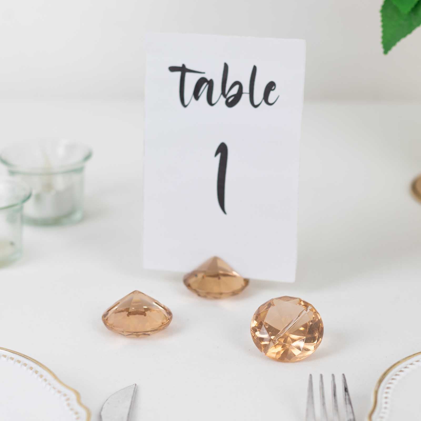 Amber diamond-shaped place card holder stands on a table setting.