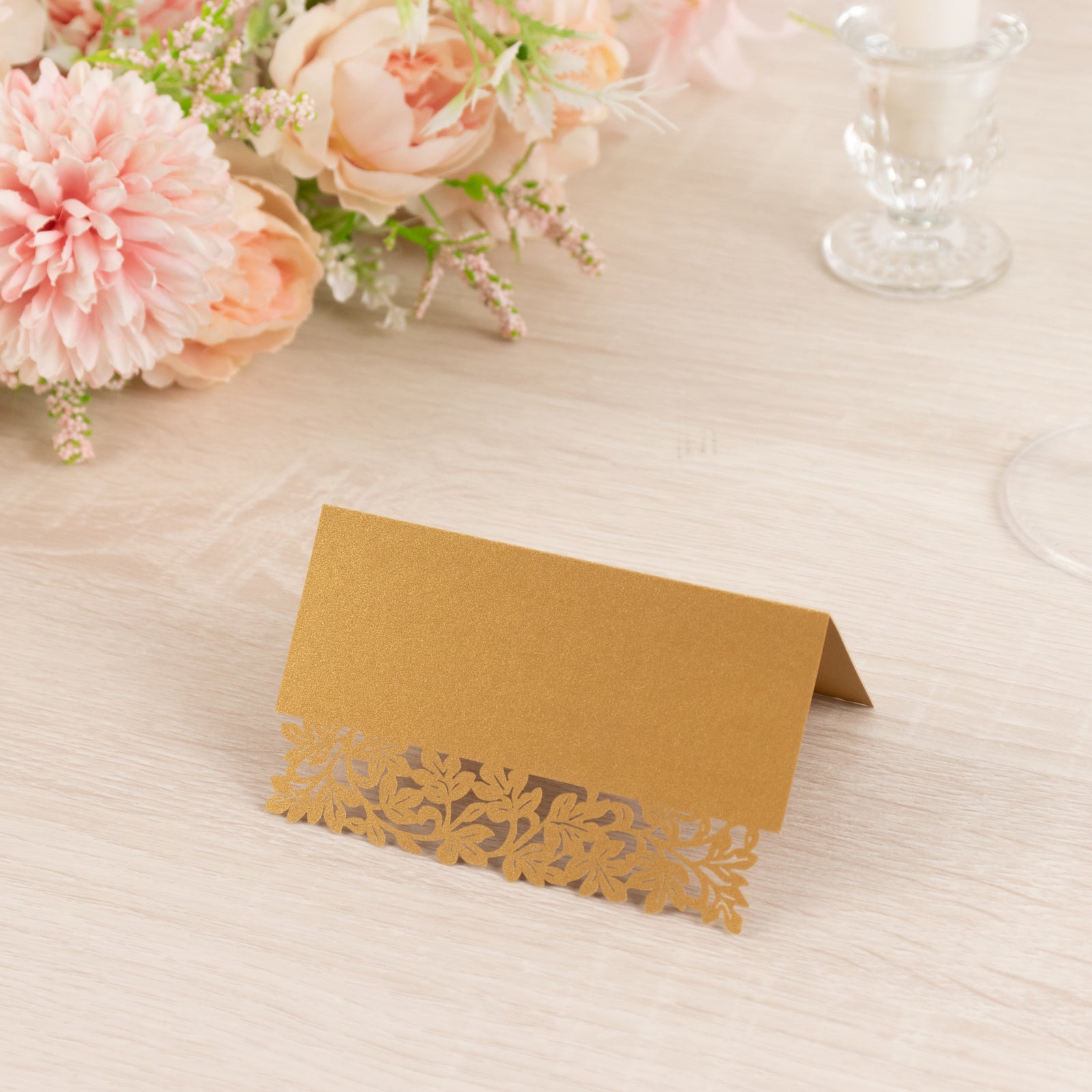 Gold wedding table number card with laser cut leaf vine design.