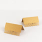 Gold wedding table number cards with laser cut leaf vine design.