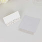White wedding table number cards with laser cut leaf vine design.