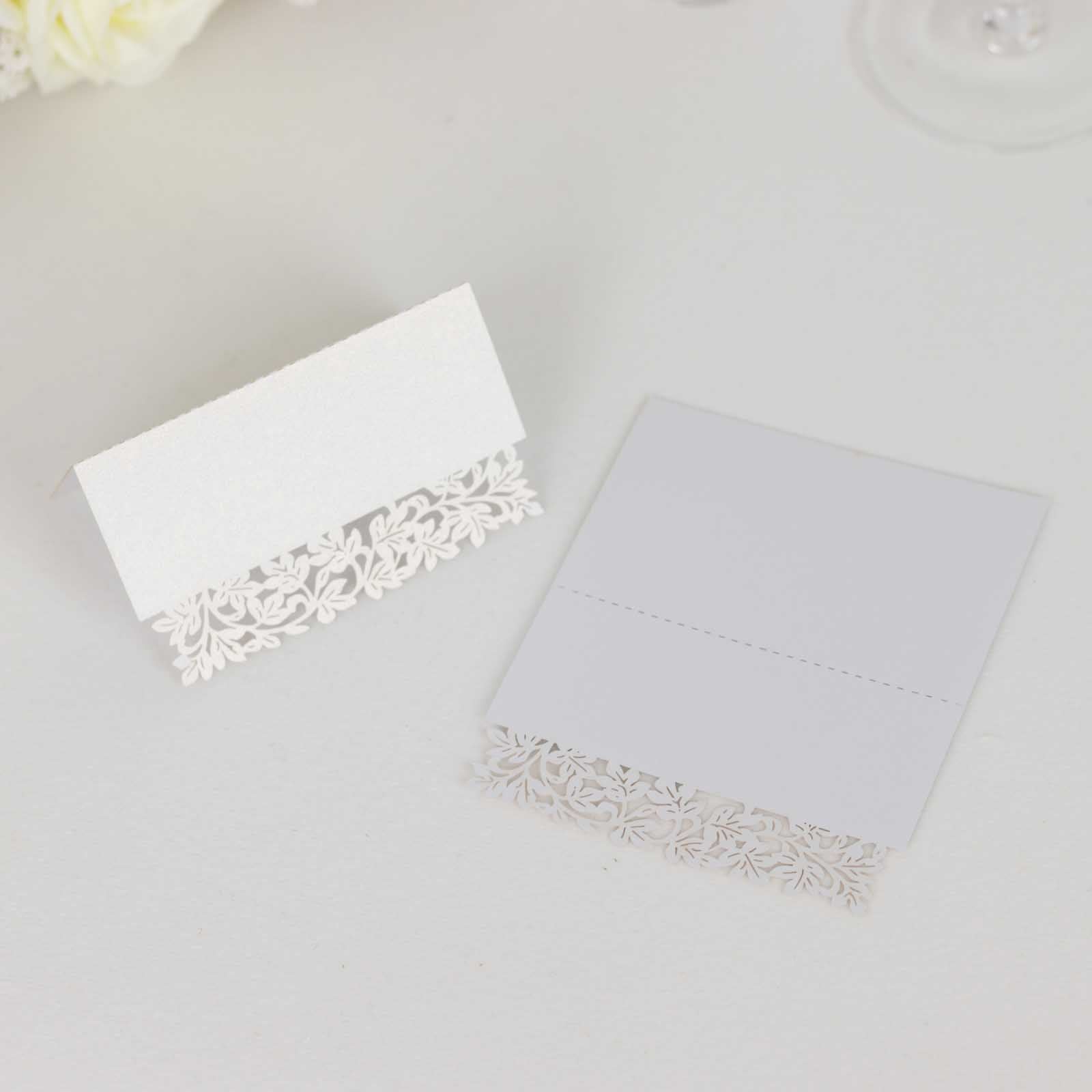 White wedding table number cards with laser cut leaf vine design.