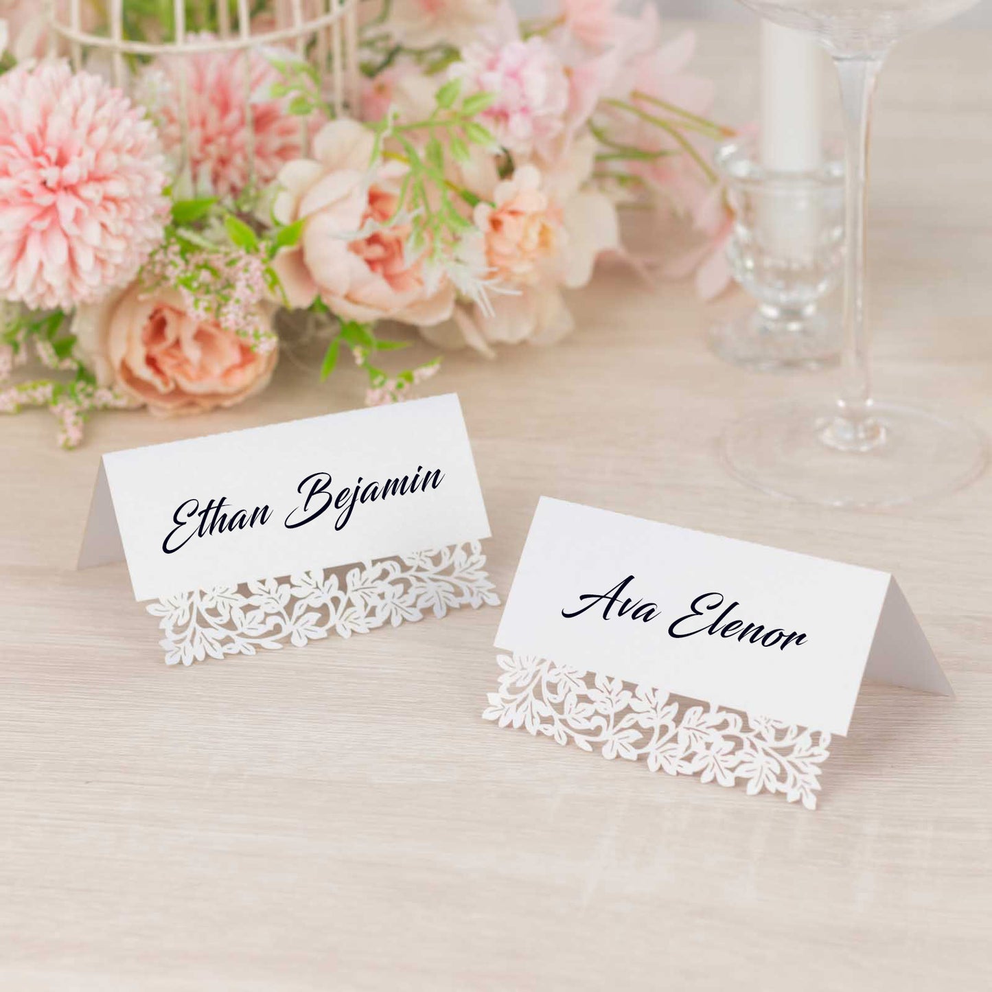 White wedding table number cards with laser cut leaf vine design.