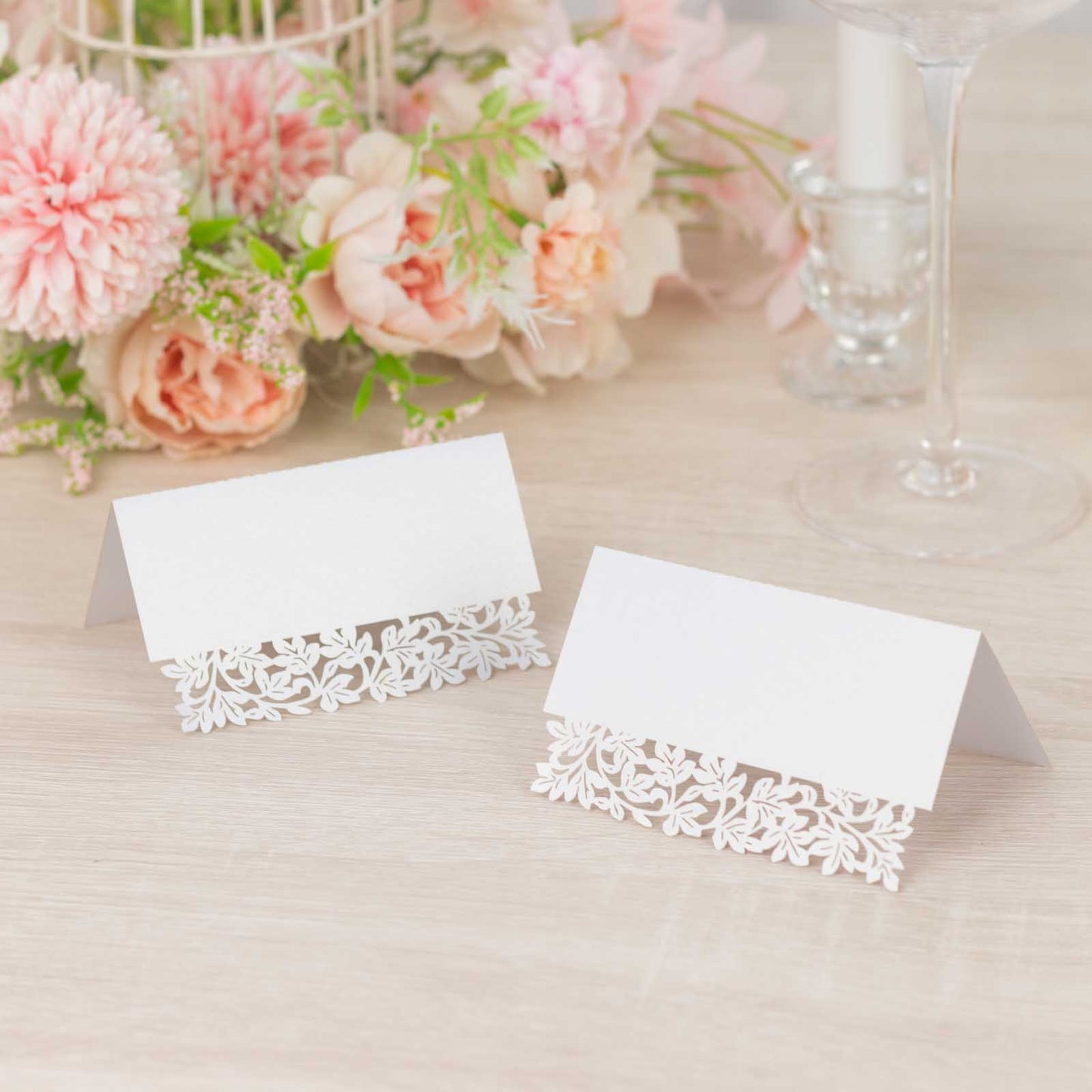 White wedding table number cards with laser cut leaf vine design.