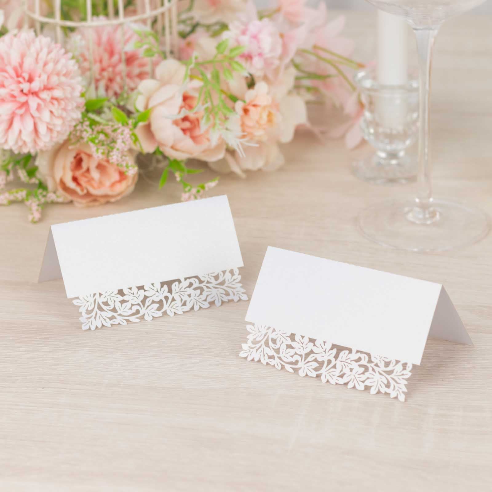 White wedding table number cards with laser cut leaf vine design.