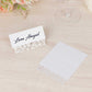 White wedding table number cards with laser cut leaf vine design.
