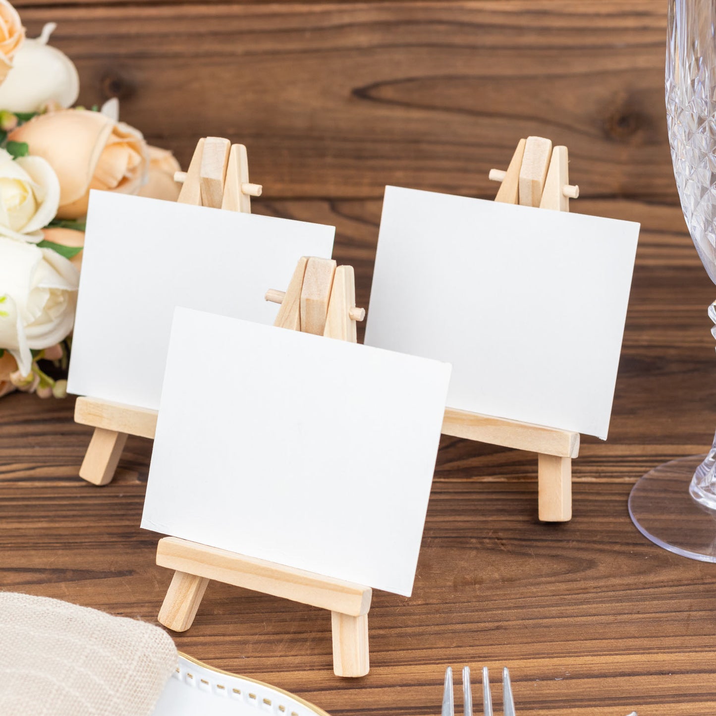 Natural mini rustic wooden place card holders on a table.
