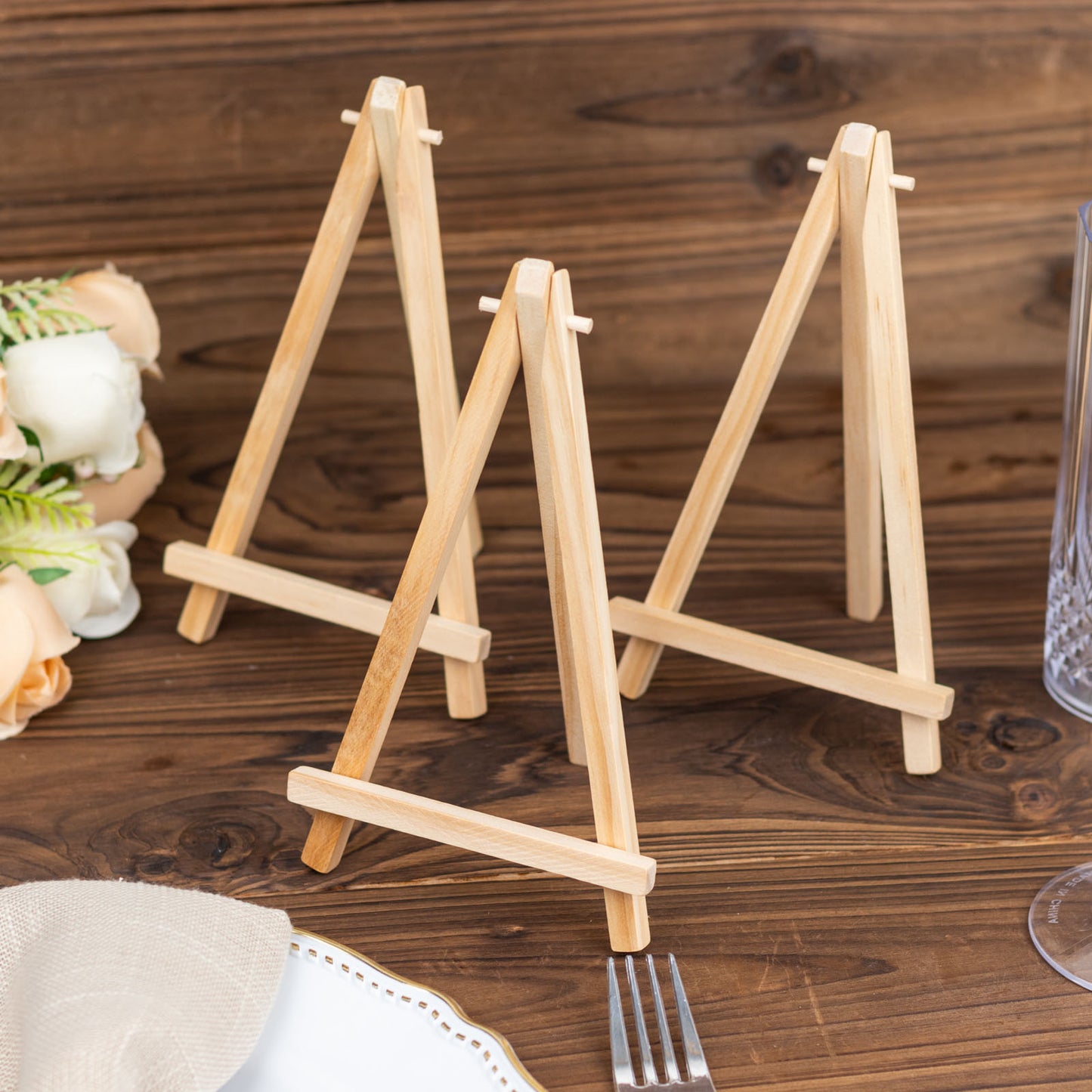 Natural wood small rustic place card holders on a table.