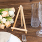 Natural wooden table number holder on a rustic table setting.