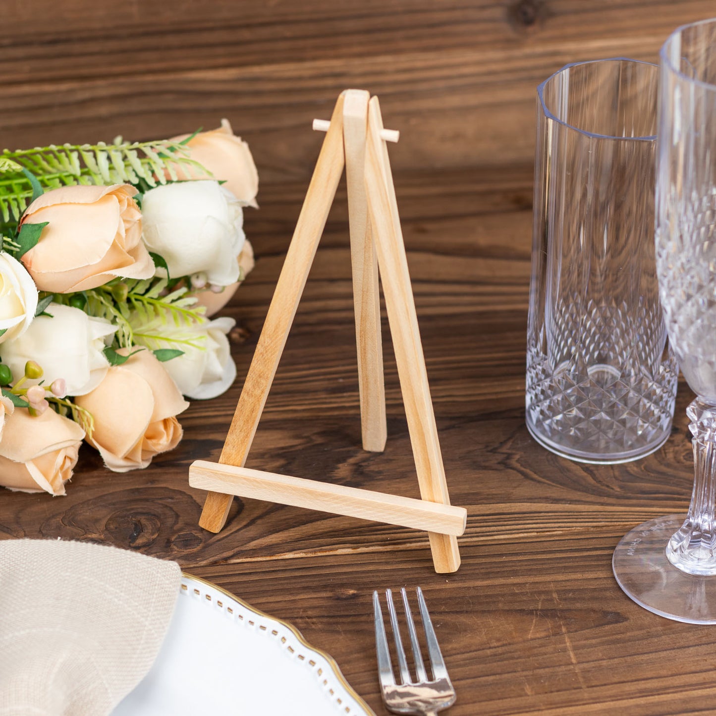 Natural wooden table number holder on a rustic table setting.