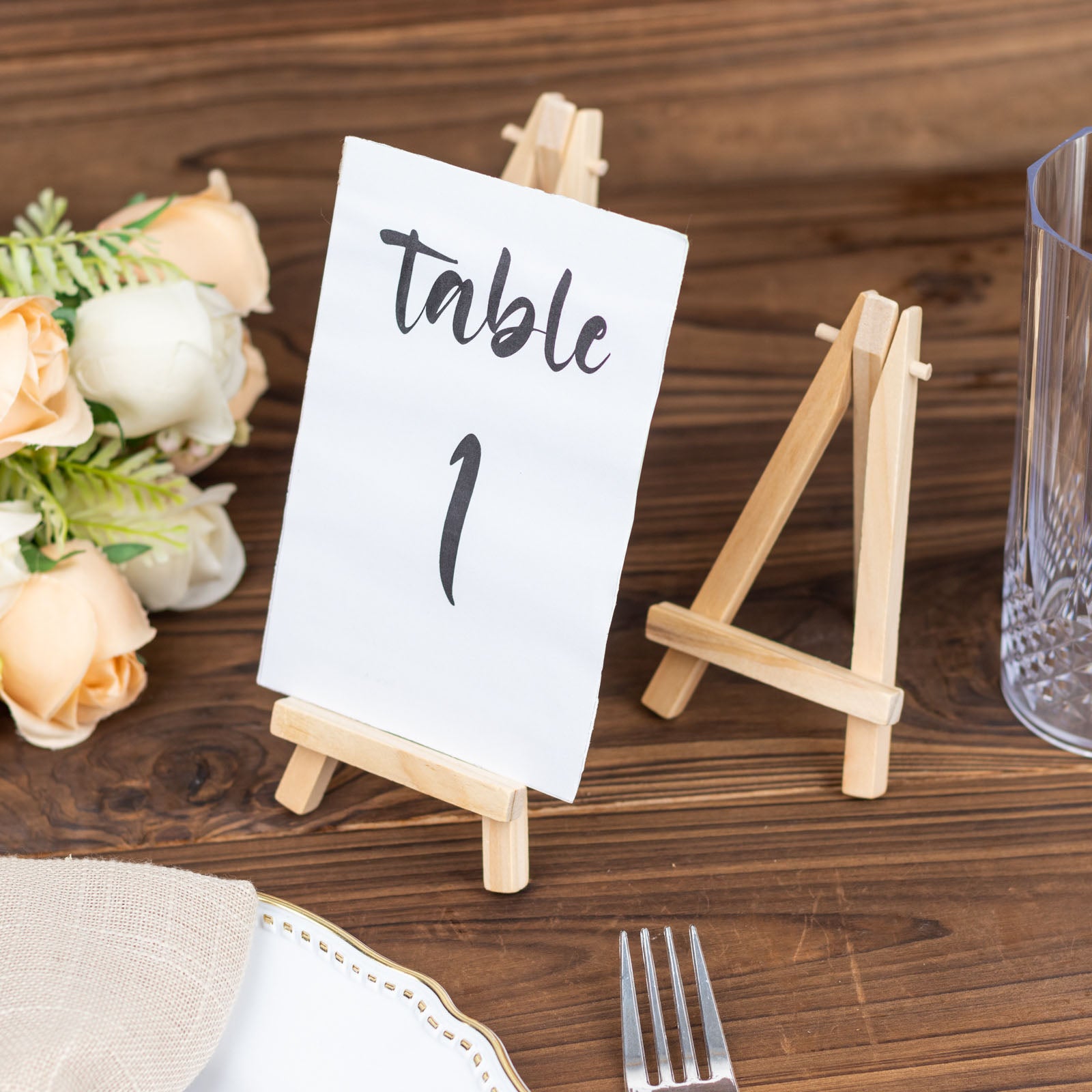 Natural small rustic wooden place card holders for table numbers.