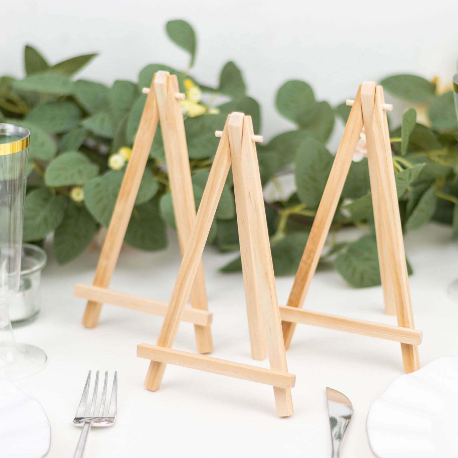 Natural wooden table number holders in a rustic setting.