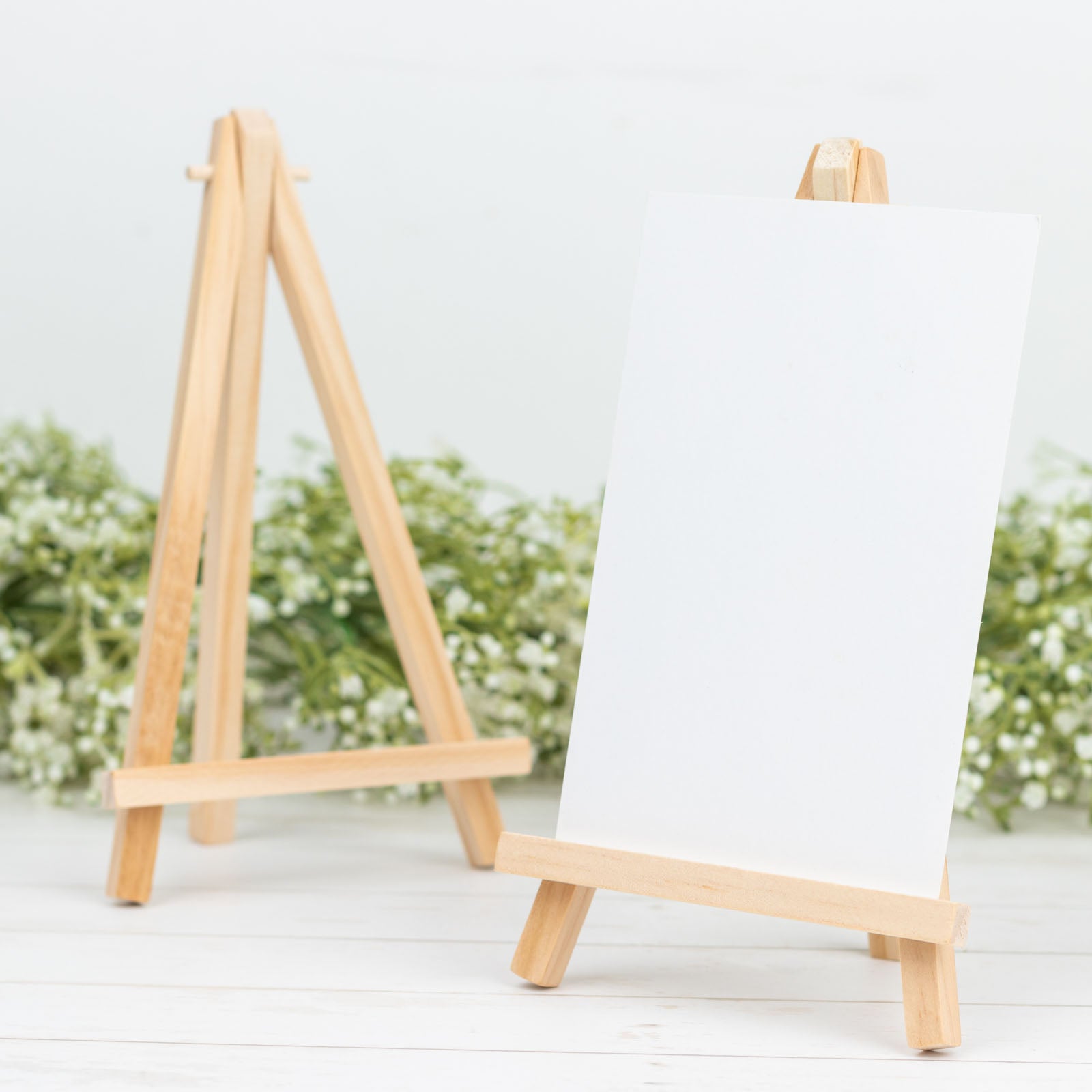 Natural small rustic wooden table number holders on a white background.