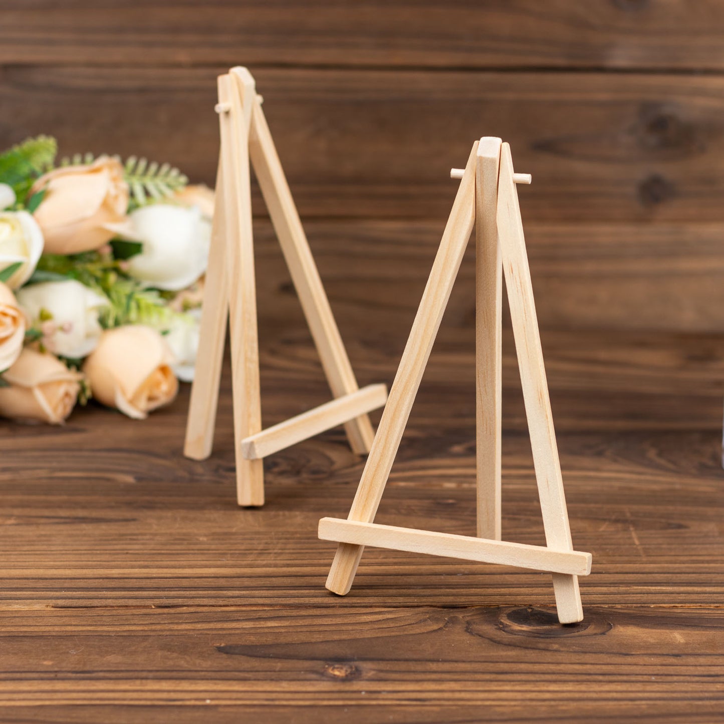 Natural wood rustic place card holders on a wooden surface.