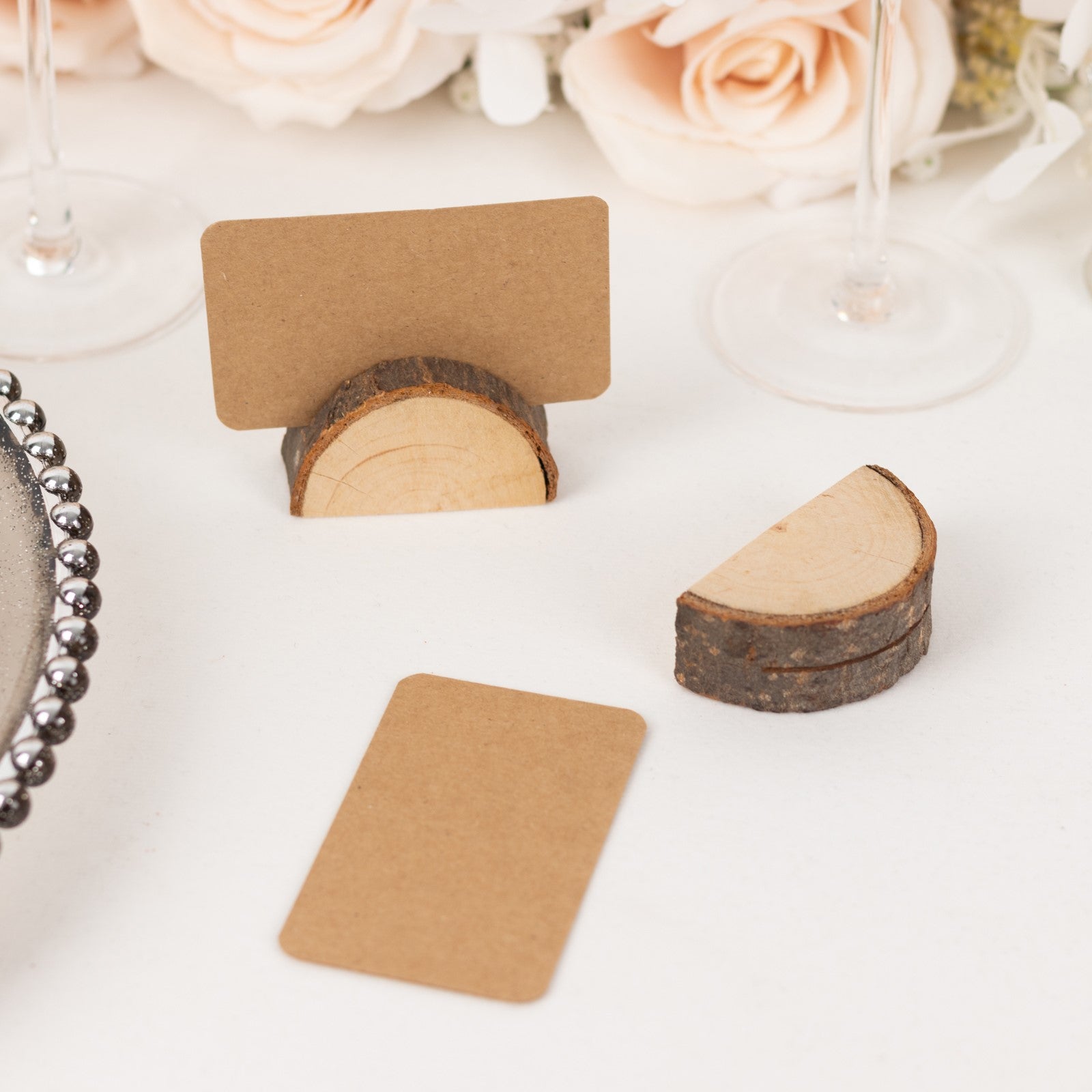 Natural wooden place card holders with brown paper cards for rustic weddings.