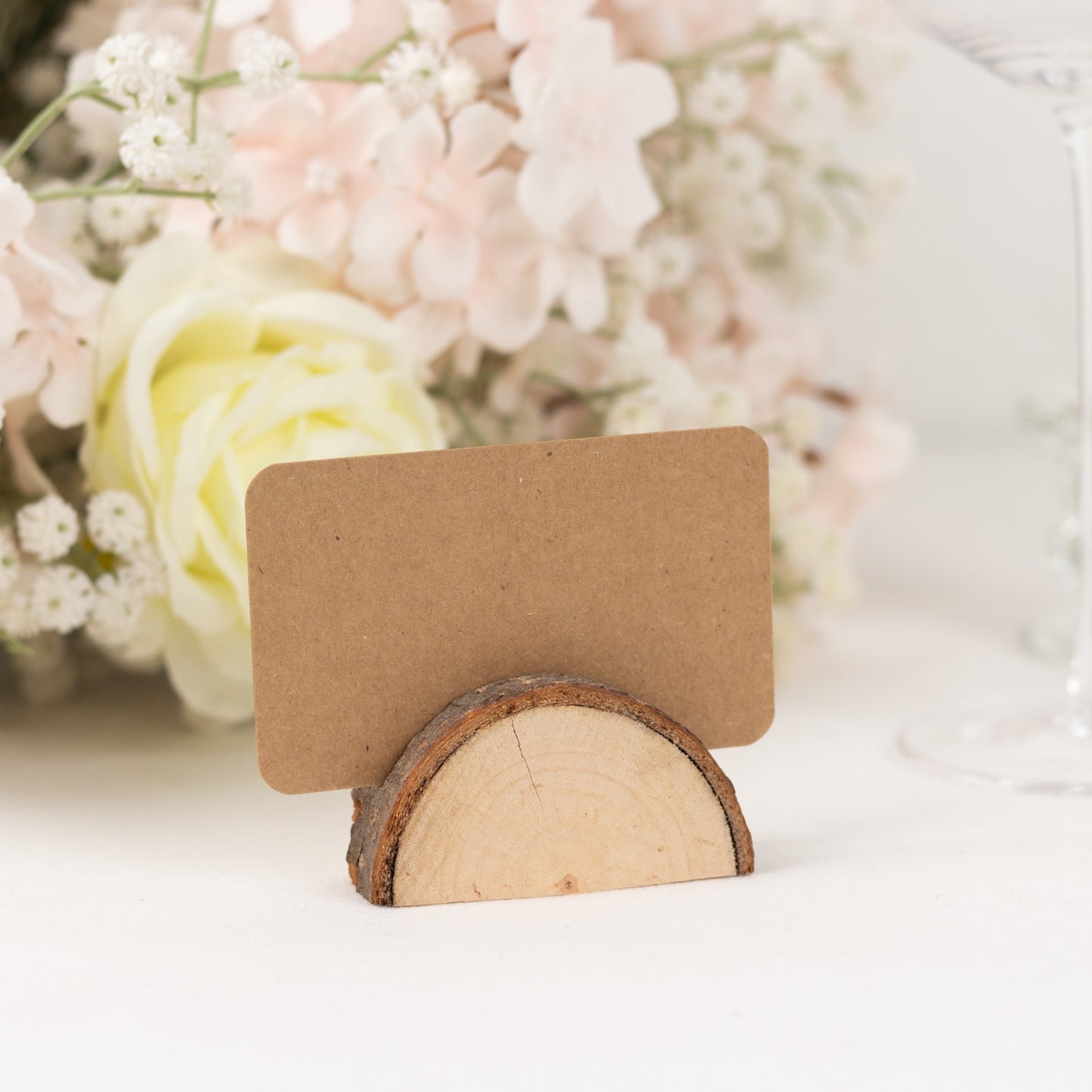 Natural wooden place card holder with brown paper card for rustic weddings.