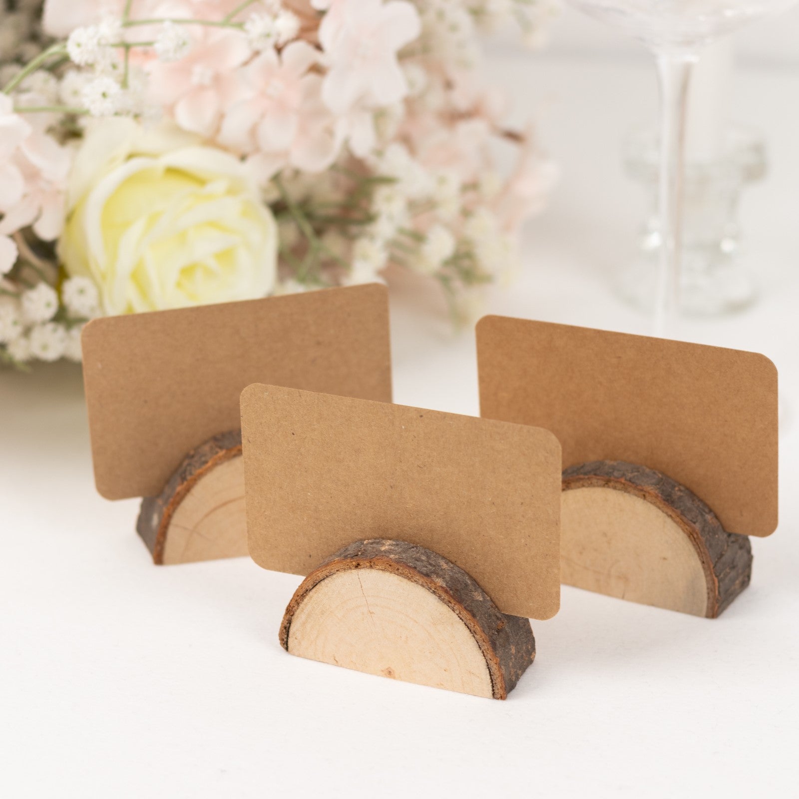 Natural wooden semicircle place card holders with brown paper cards.