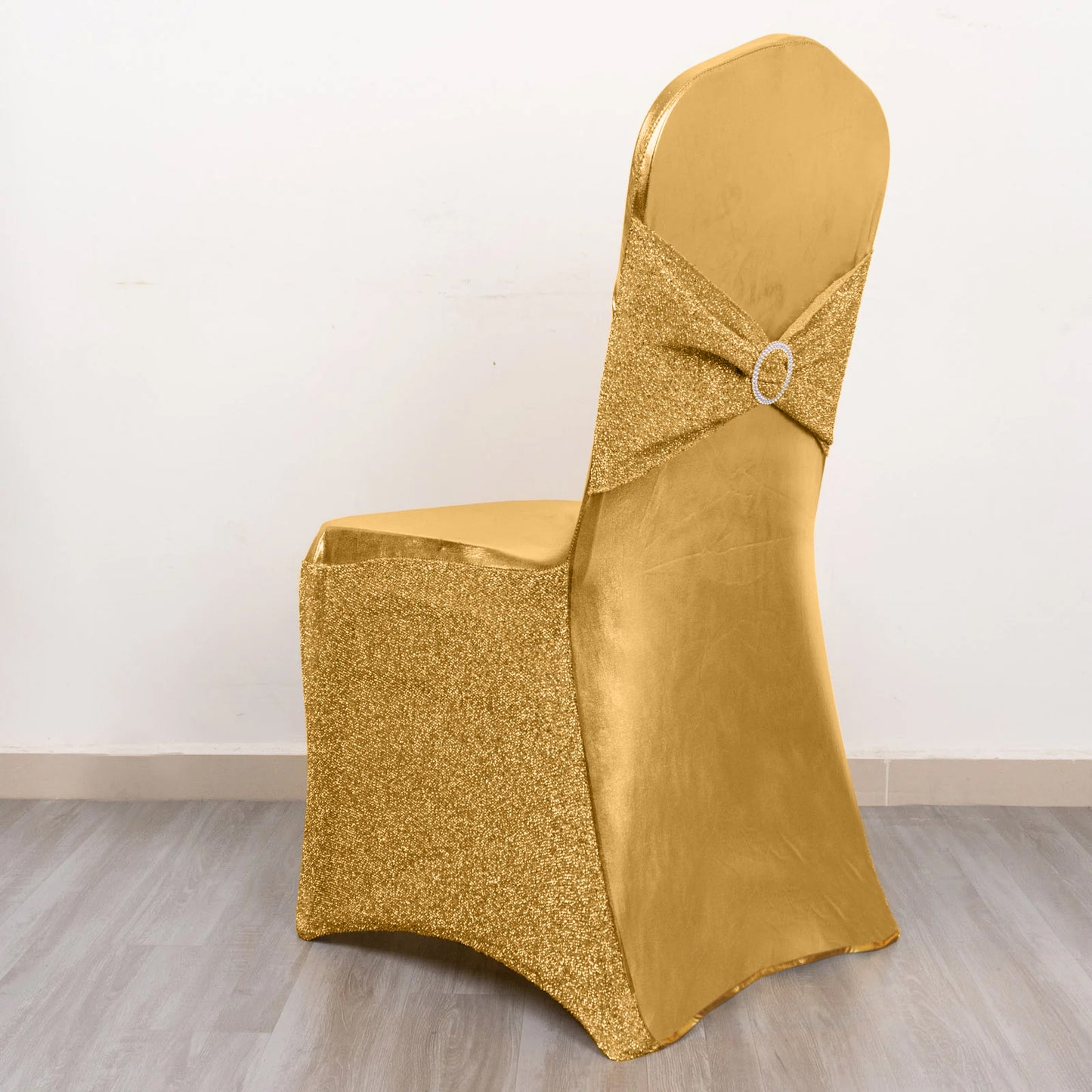 Metallic gold shimmer tinsel spandex chair cover with attached sash and rhinestone buckle.