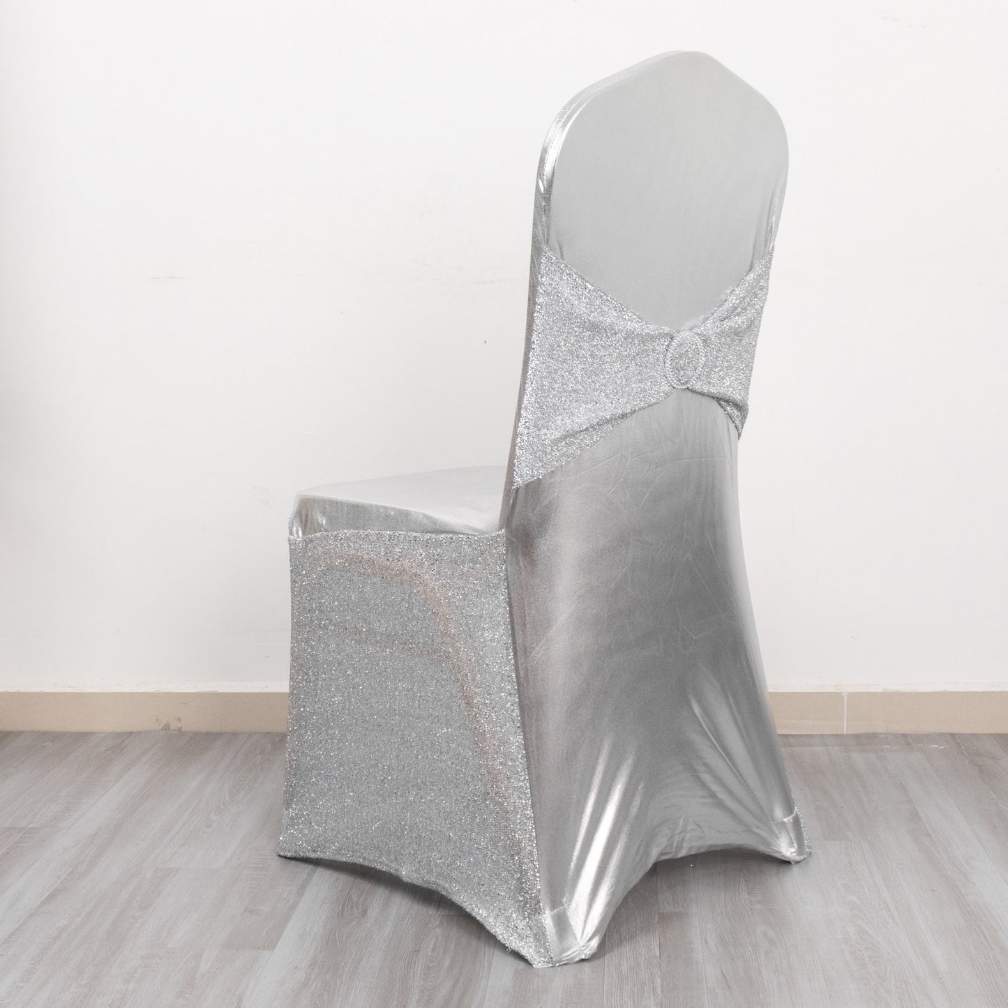 Metallic silver shimmer tinsel spandex chair cover with attached sash.