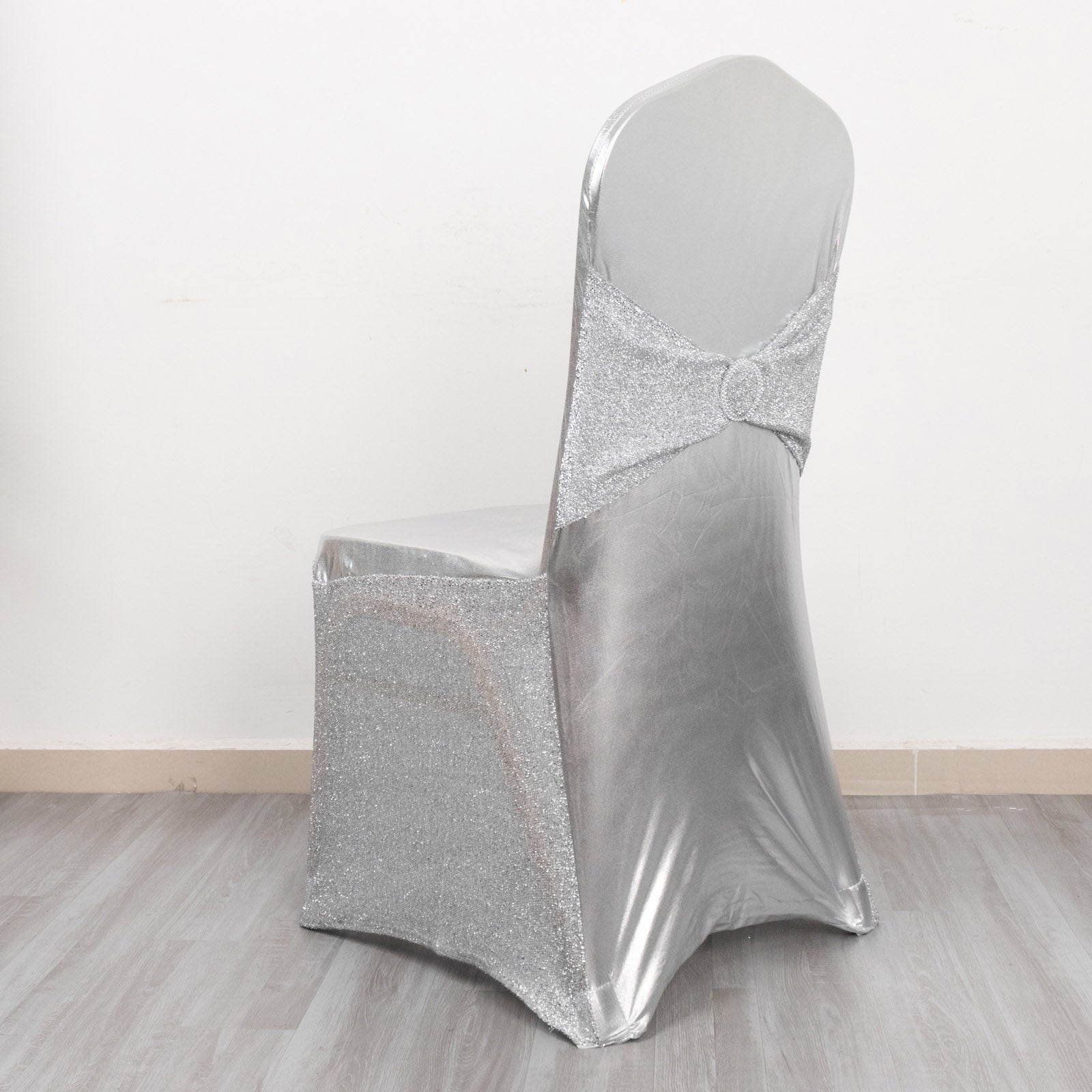 Metallic silver shimmer tinsel spandex chair cover with attached sash.