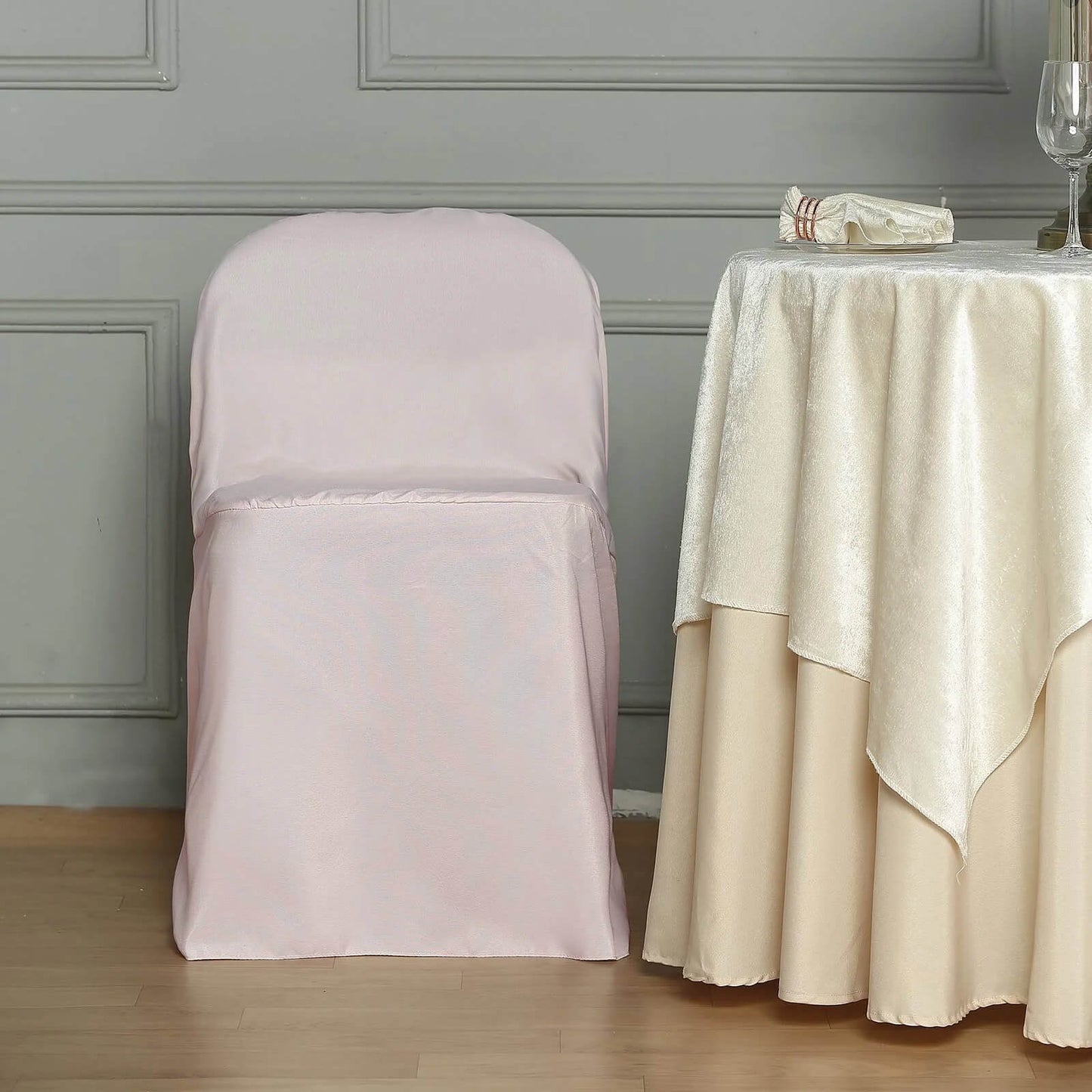 Blush polyester folding chair cover on a chair.