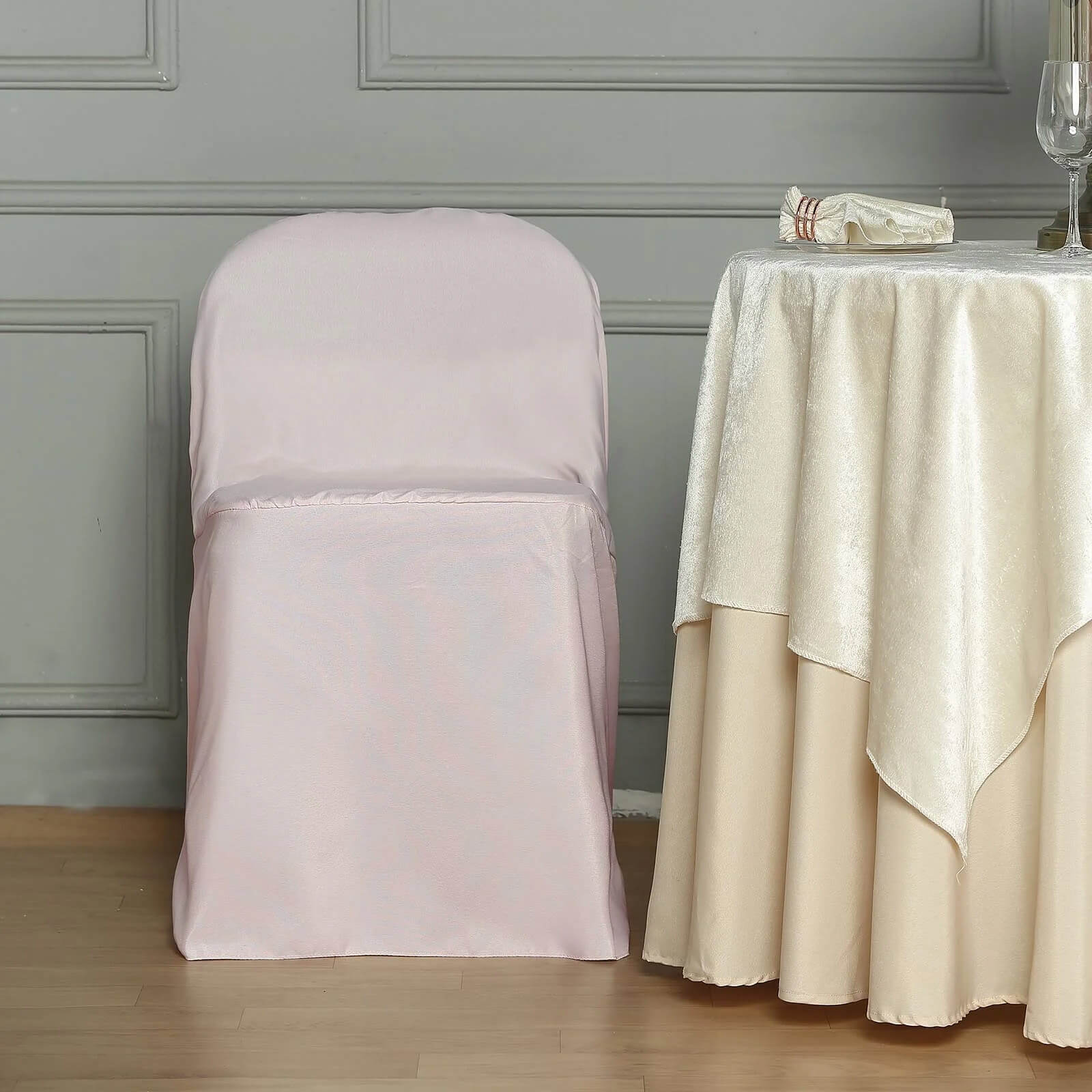 Blush polyester folding chair cover on a chair.