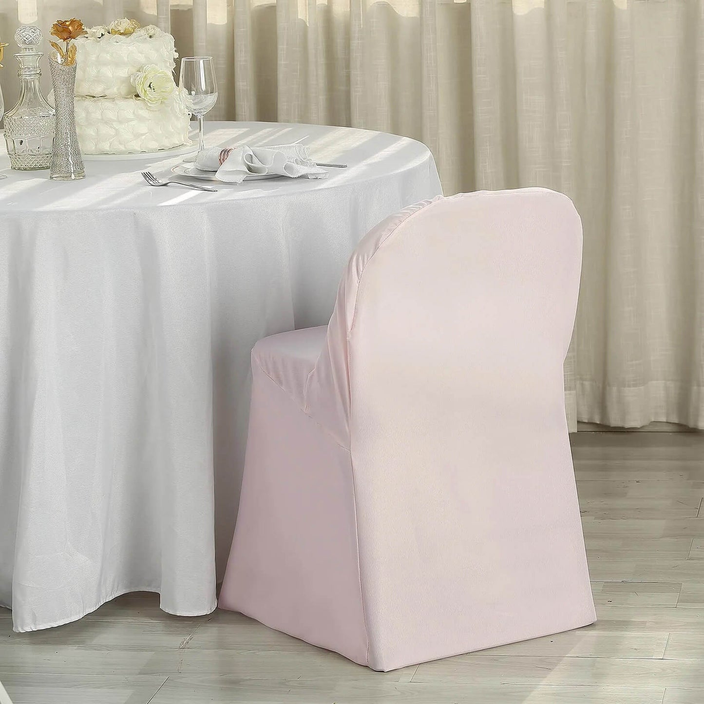 Blush polyester folding chair cover on a table setting.