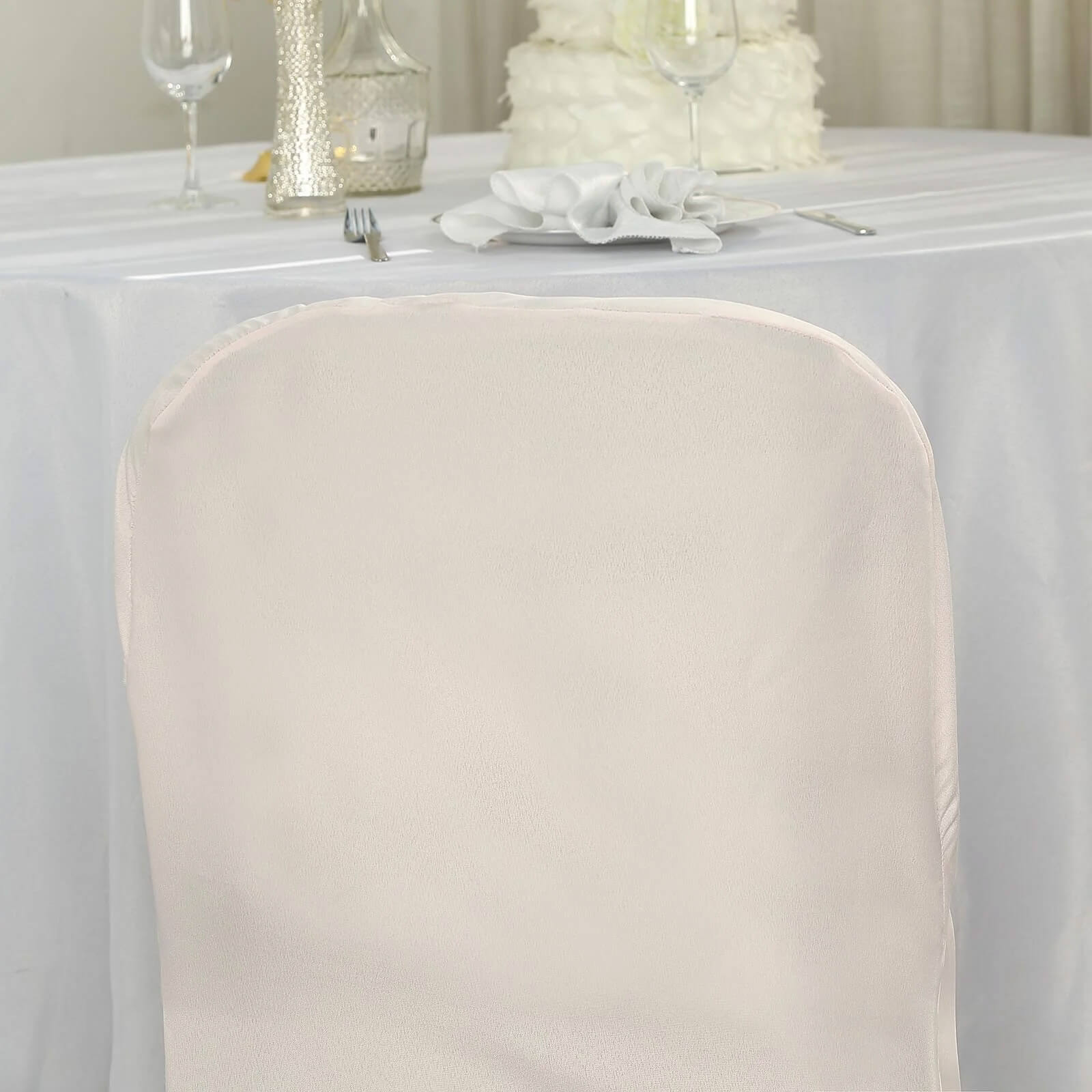 Blush polyester folding chair cover on a banquet chair.