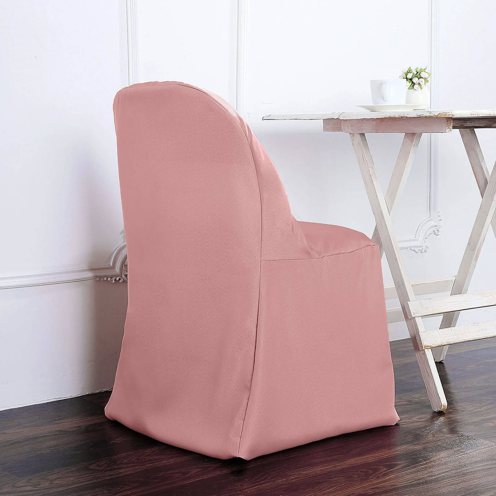 Dusty rose polyester folding chair cover on a chair.