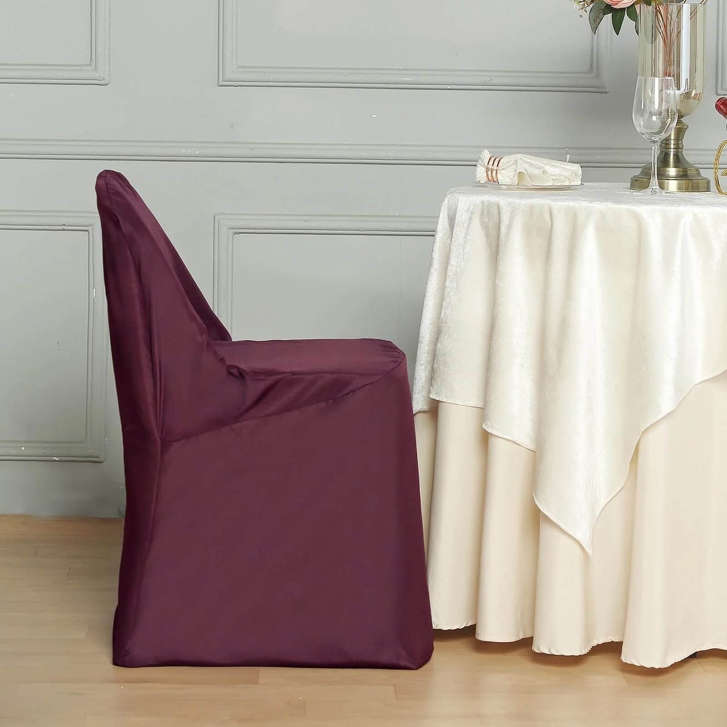 Burgundy polyester folding chair cover on a chair.