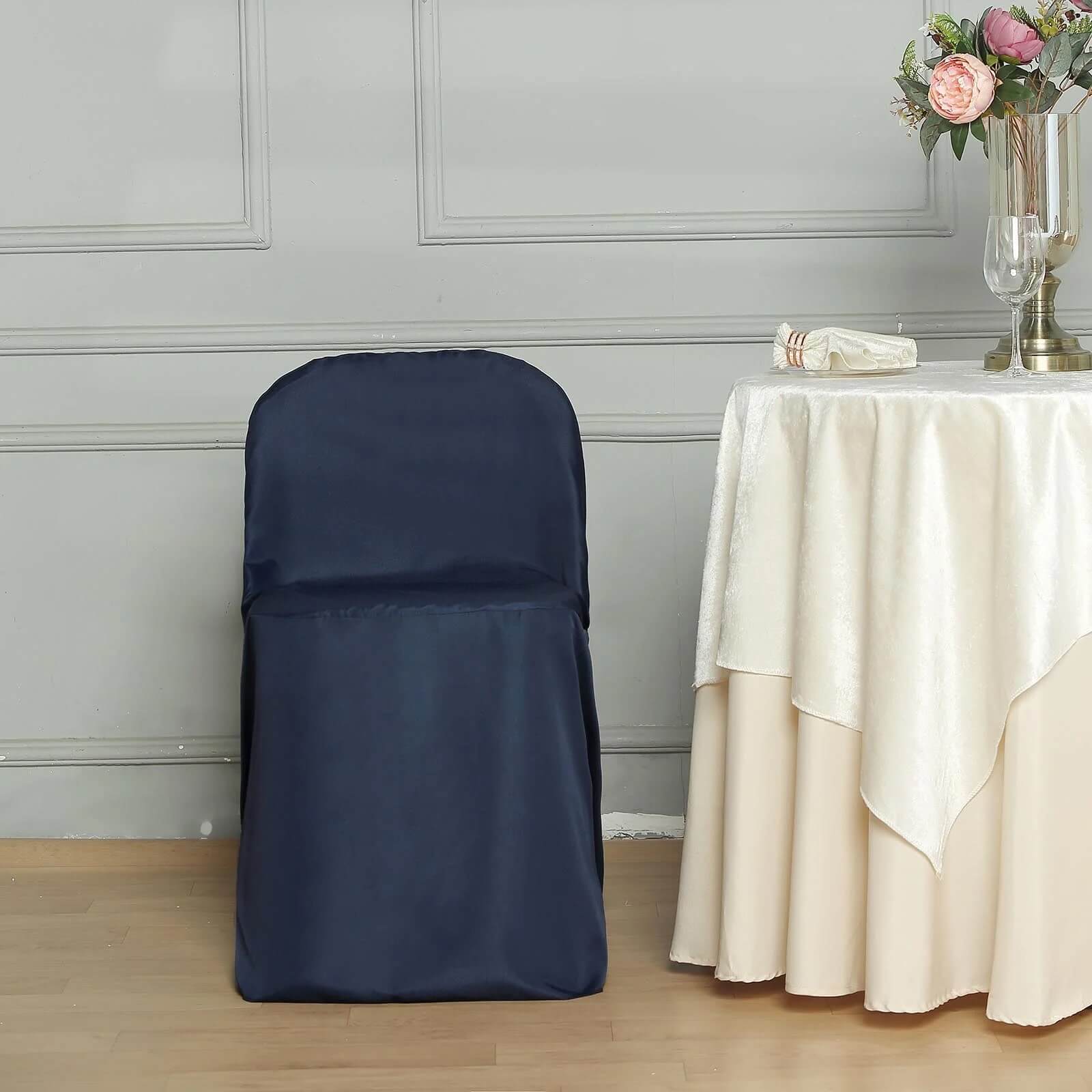 Navy blue polyester folding chair cover on a wooden floor.