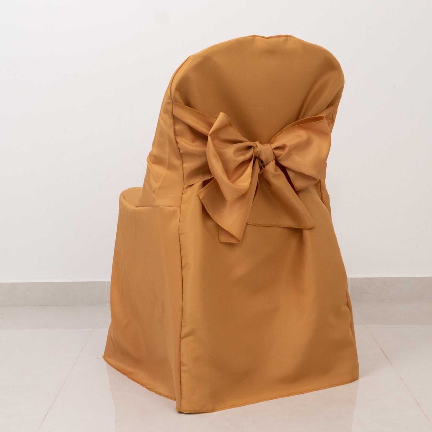 Gold slip-on folding chair cover with attached sash for events.